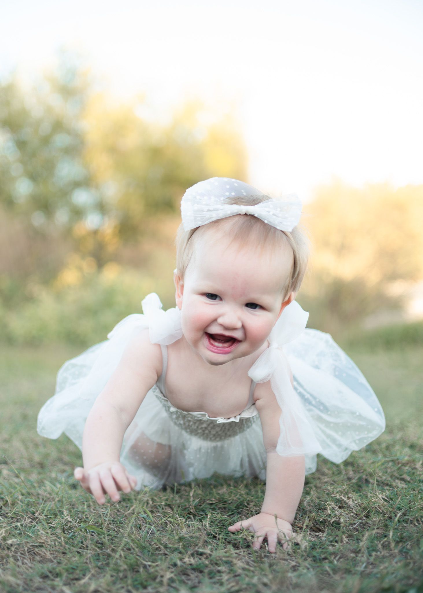 One year old girl crawling during outdoor family session at Salado Creek in Salado Texas