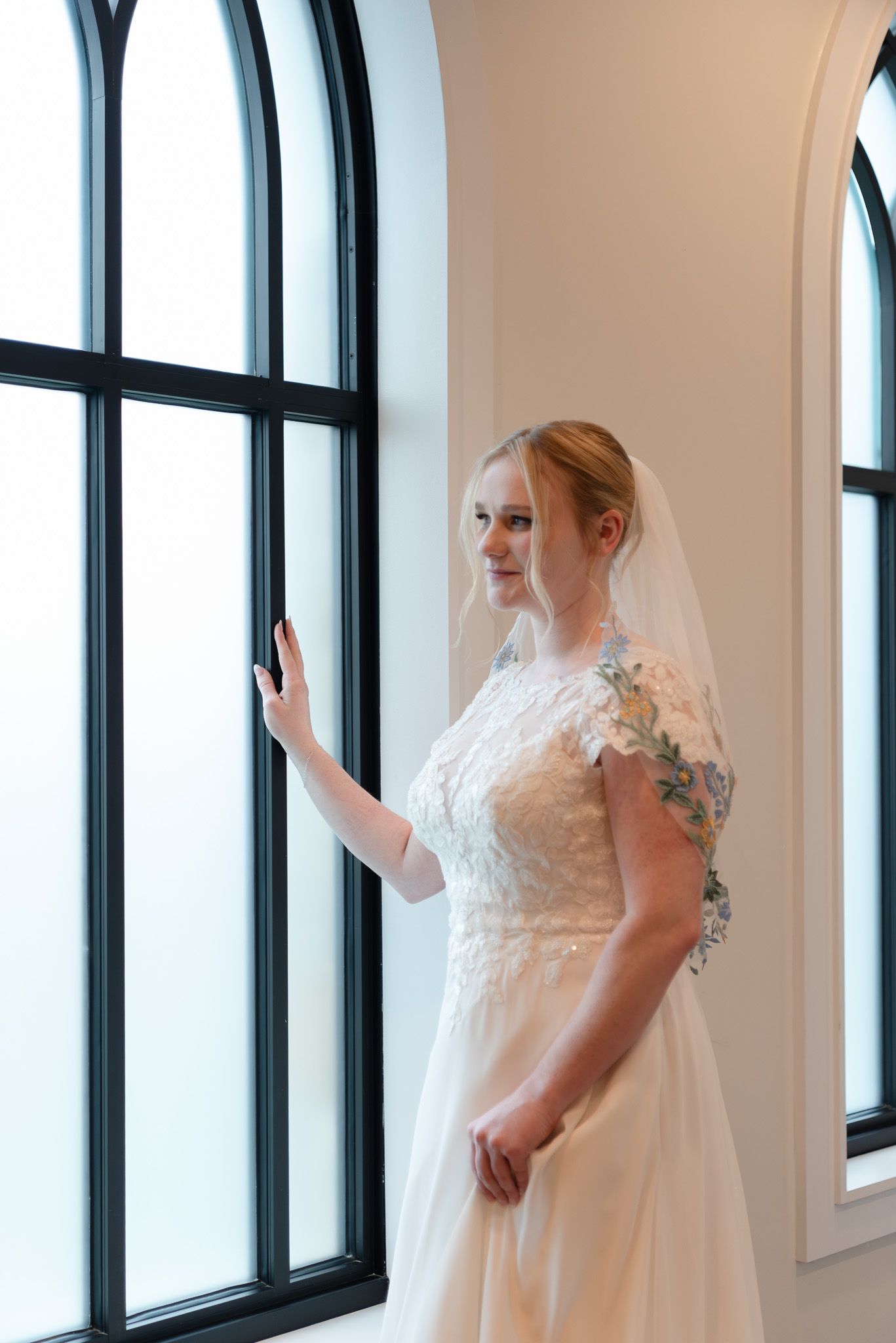 Bride looking out window at Life Austin Chapel in Austin Texas on her wedding day
