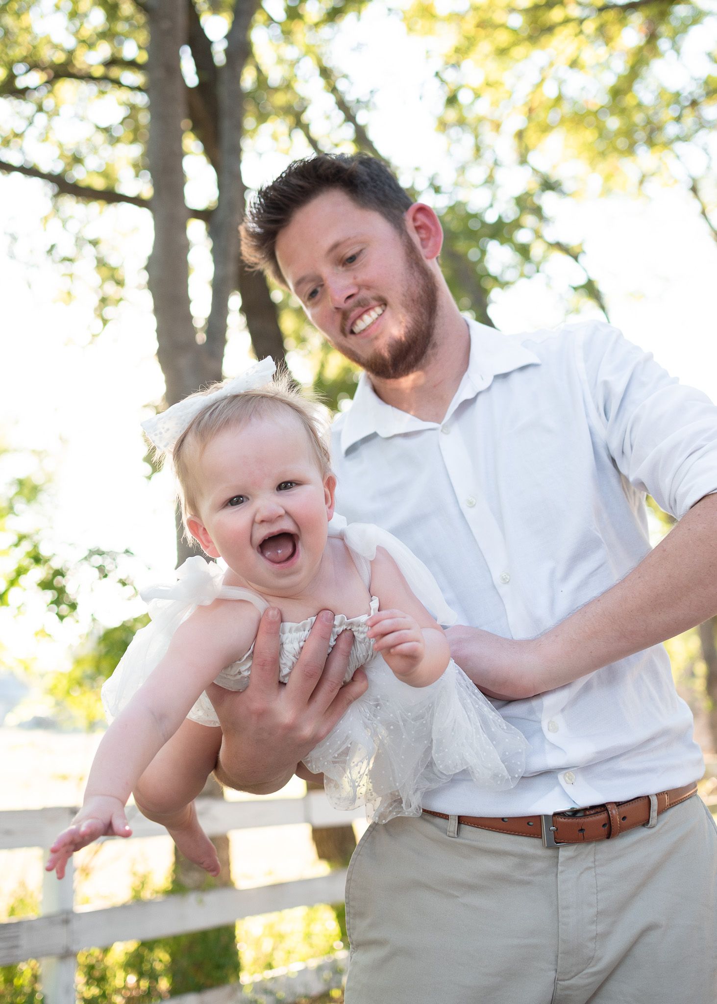 Father playing with baby during outdoor family session at Pace Park in Salado Texas