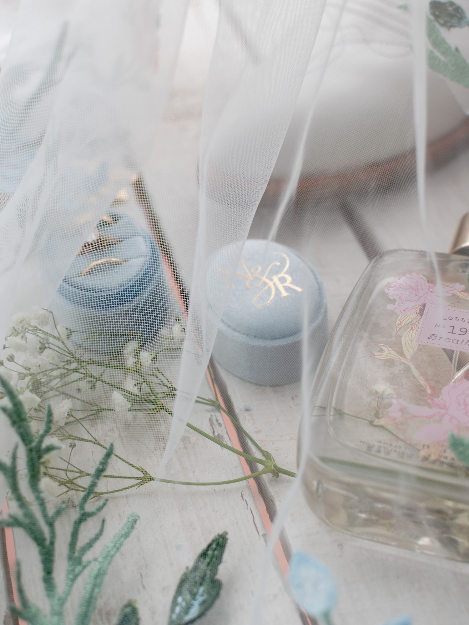 Wedding details flatlay with veil, rings, and perfume in Dripping Springs Texas