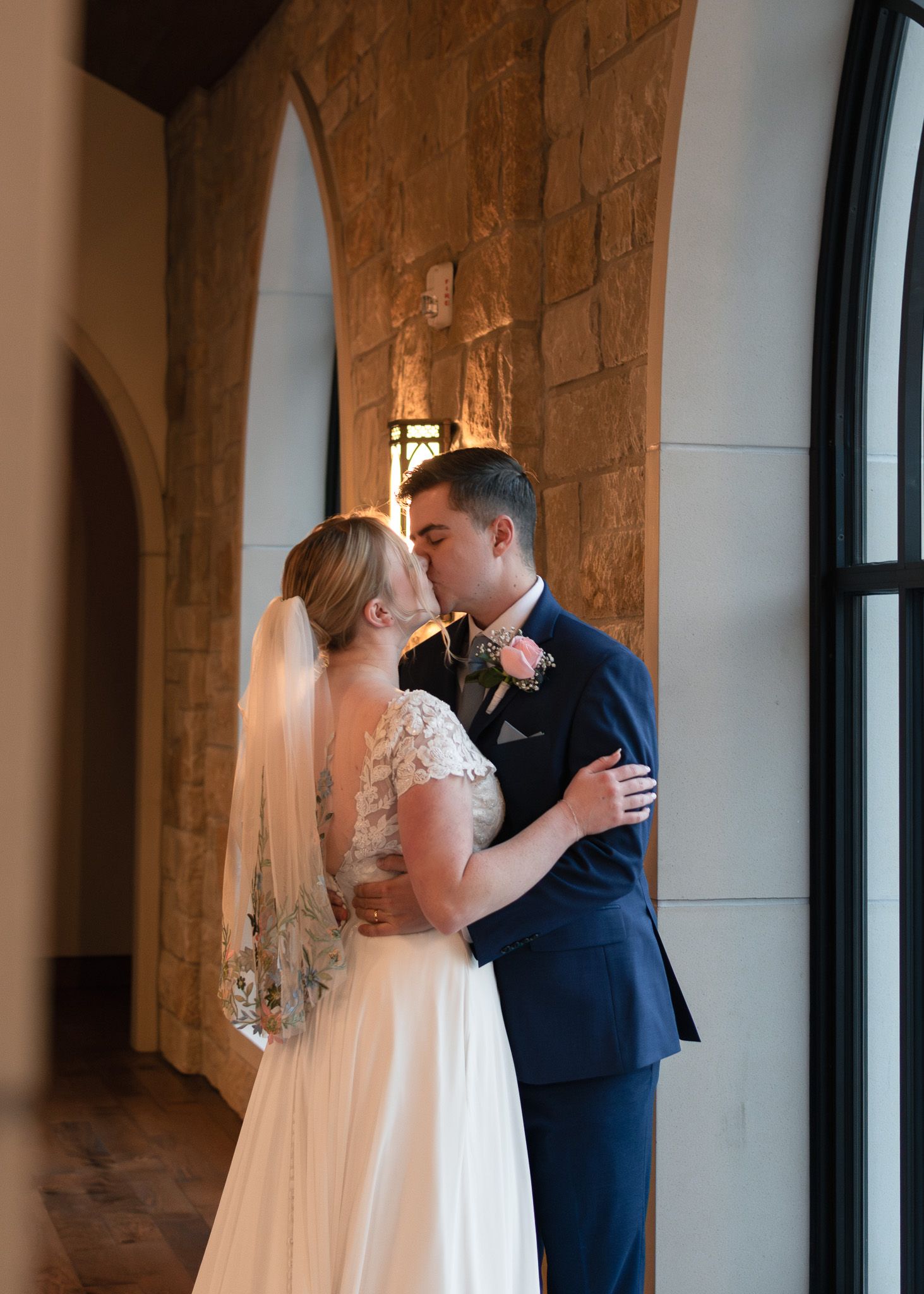 Bride and groom standing by window at Life Austin Chapel in Austin Texas
