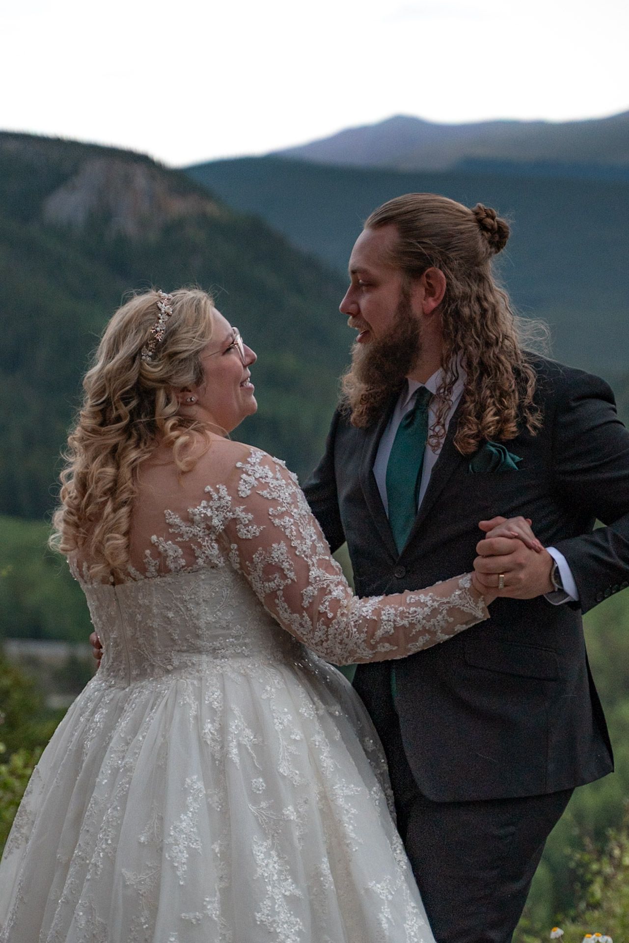A couple dances together at their mountain wedding with scenic views in the background.