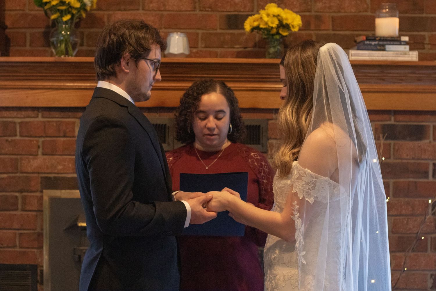 A series of photos showing a wedding ceremony in progress at a rustic brick-walled venue with yellow floral accents.