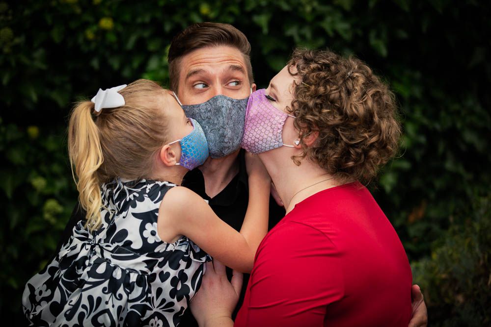 Family members sharing affectionate moments during outdoor portrait session.