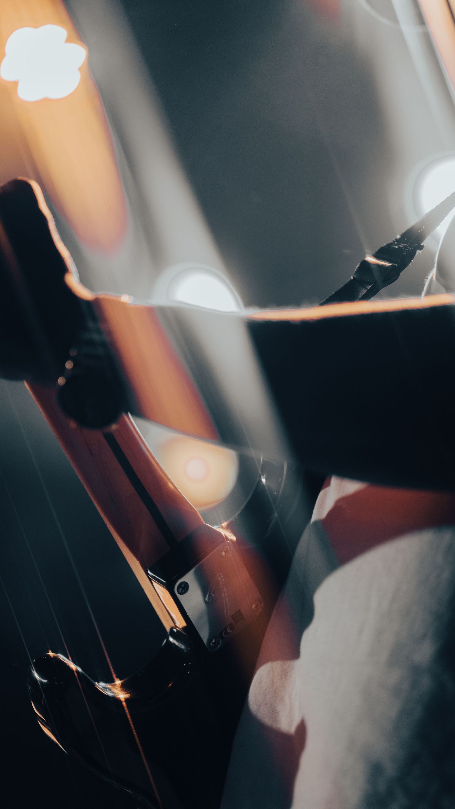 Close-up of an electric guitar neck with bokeh stage lights in the background.