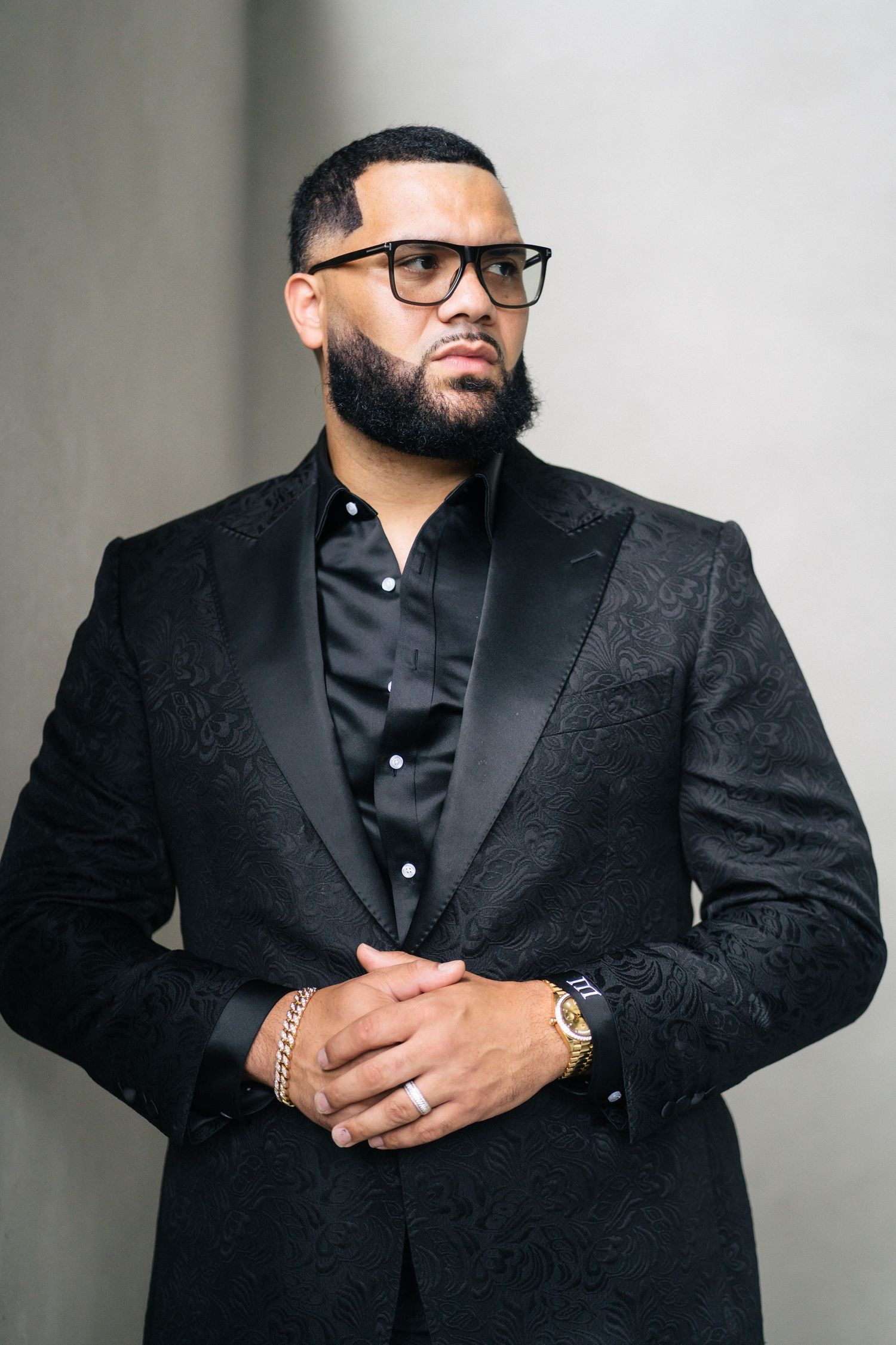 Side profile portrait of person wearing black formal attire and glasses.