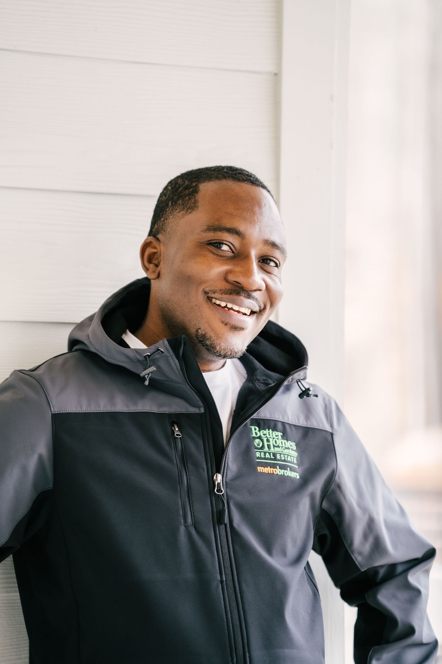 A collage of three photos showing someone wearing a black and gray company uniform jacket while smiling.