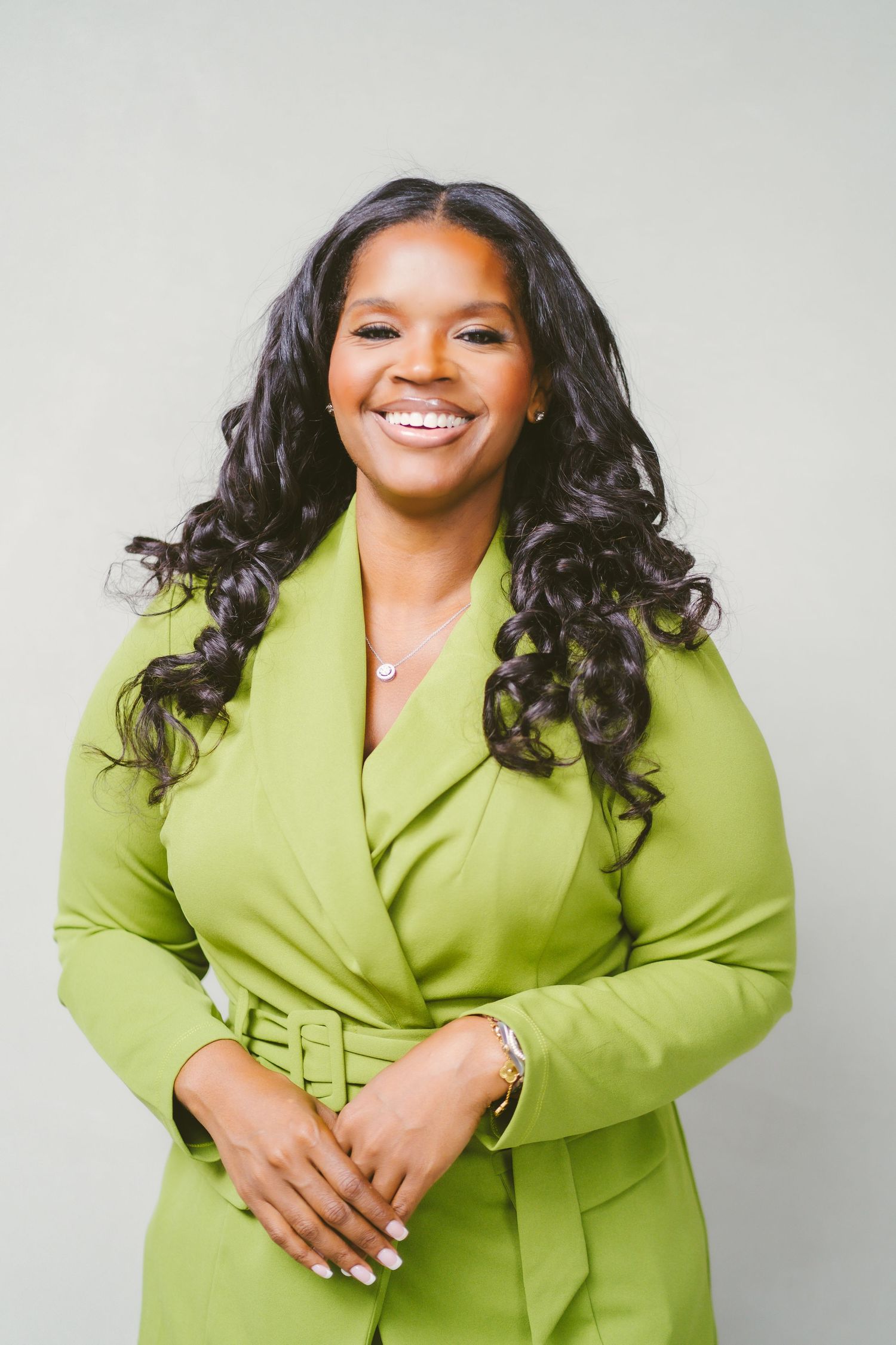 Professional studio portrait session featuring a lime green blazer against a light gray background.