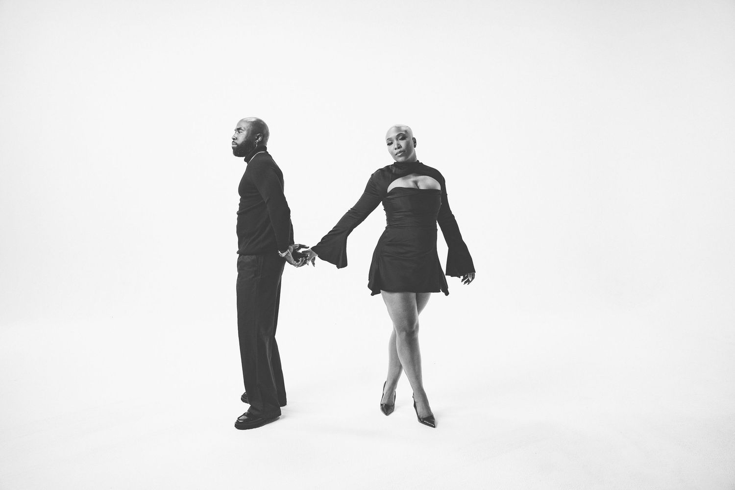 Black and white silhouettes of people dancing against a white background.