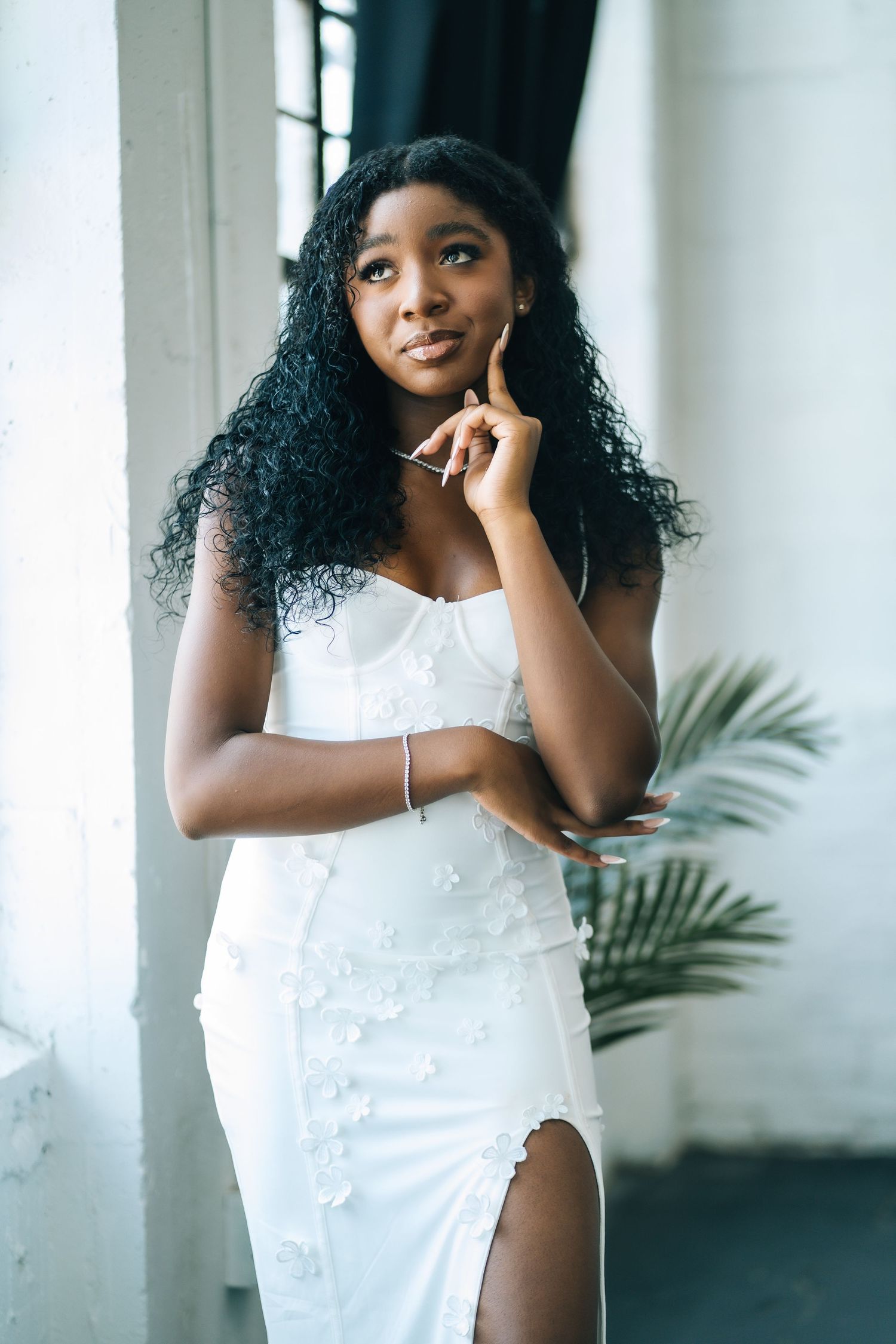 Elegant portrait series in a white dress showing different poses against a bright interior backdrop.