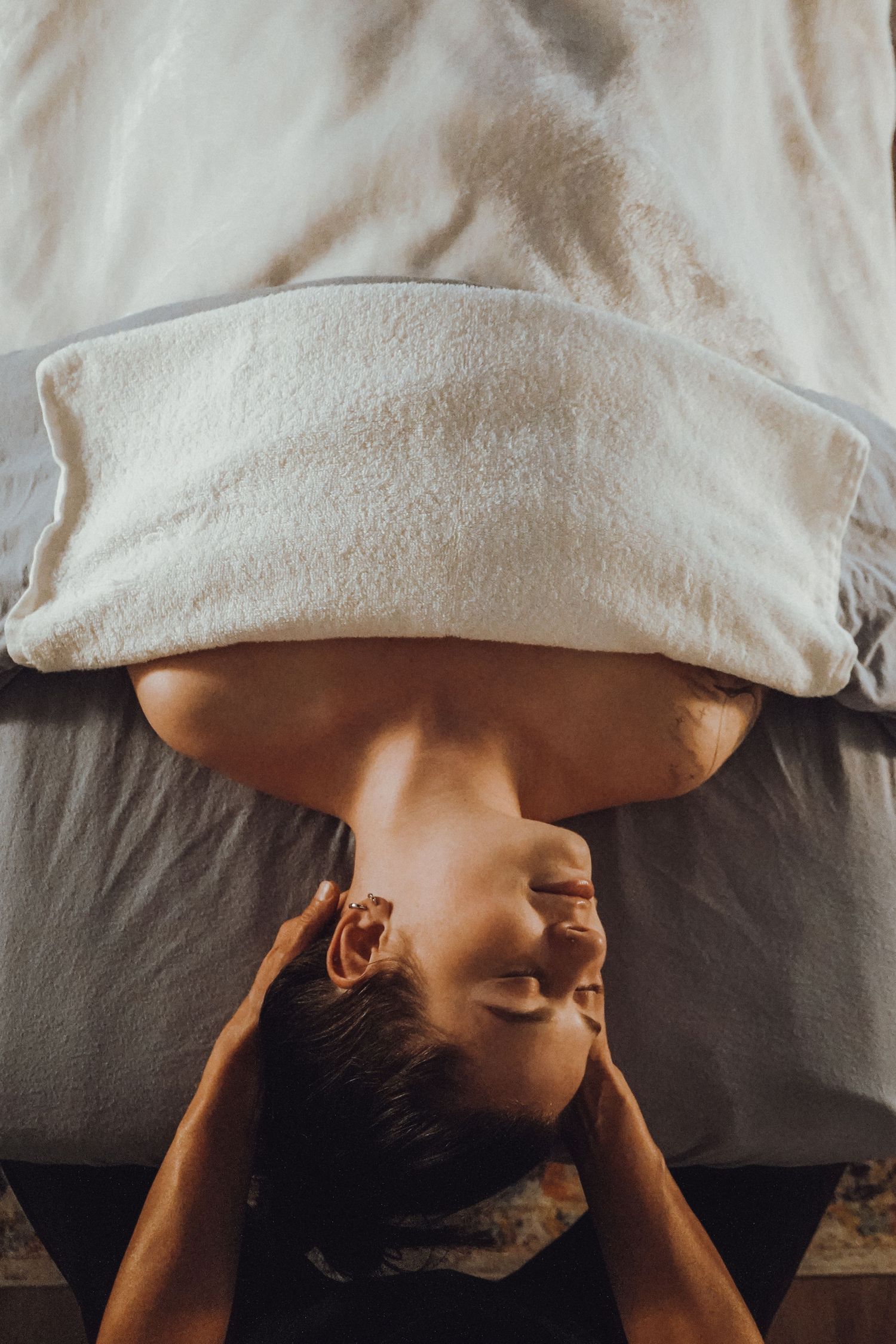 Person lying down with a white towel during a spa treatment.