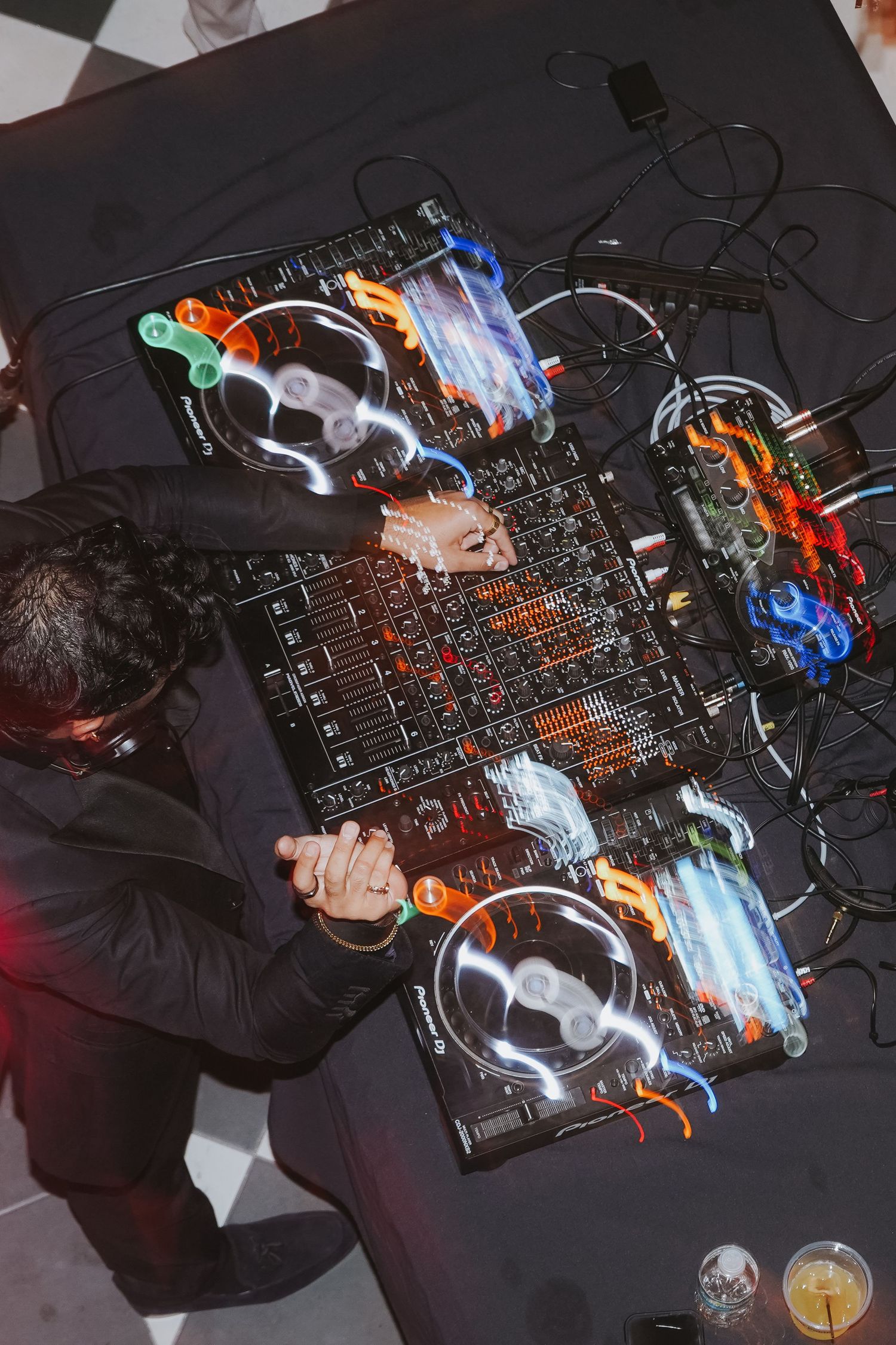 DJ mixing music on professional equipment with colorful lights and effects.