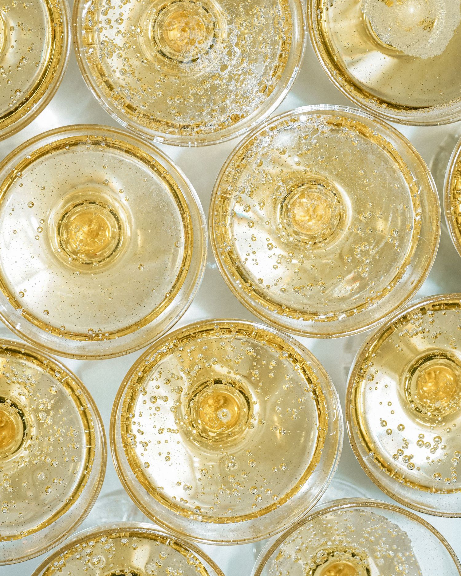 Overhead view of champagne flutes filled with bubbly golden liquid.