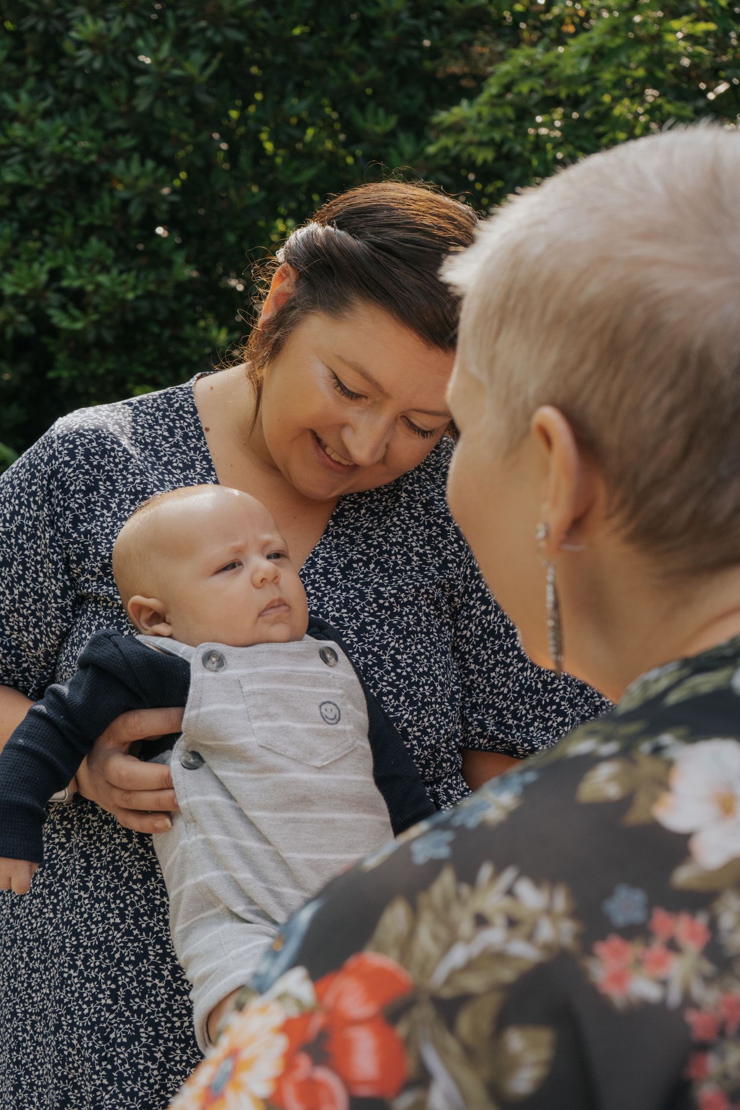 A tender moment shared between family members as they gather around a small baby.