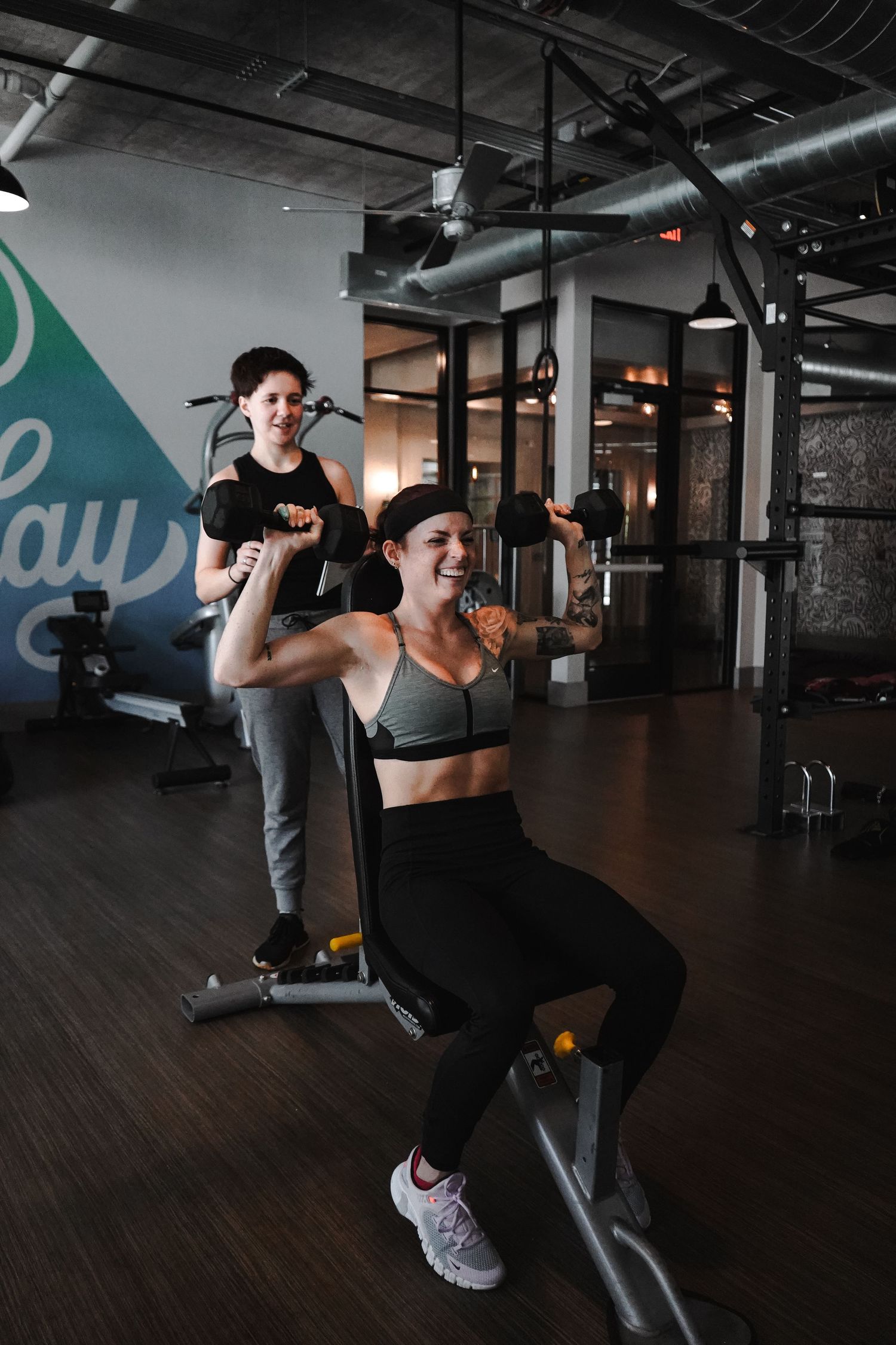 Personal training session at gym with lat pulldown machine exercise.