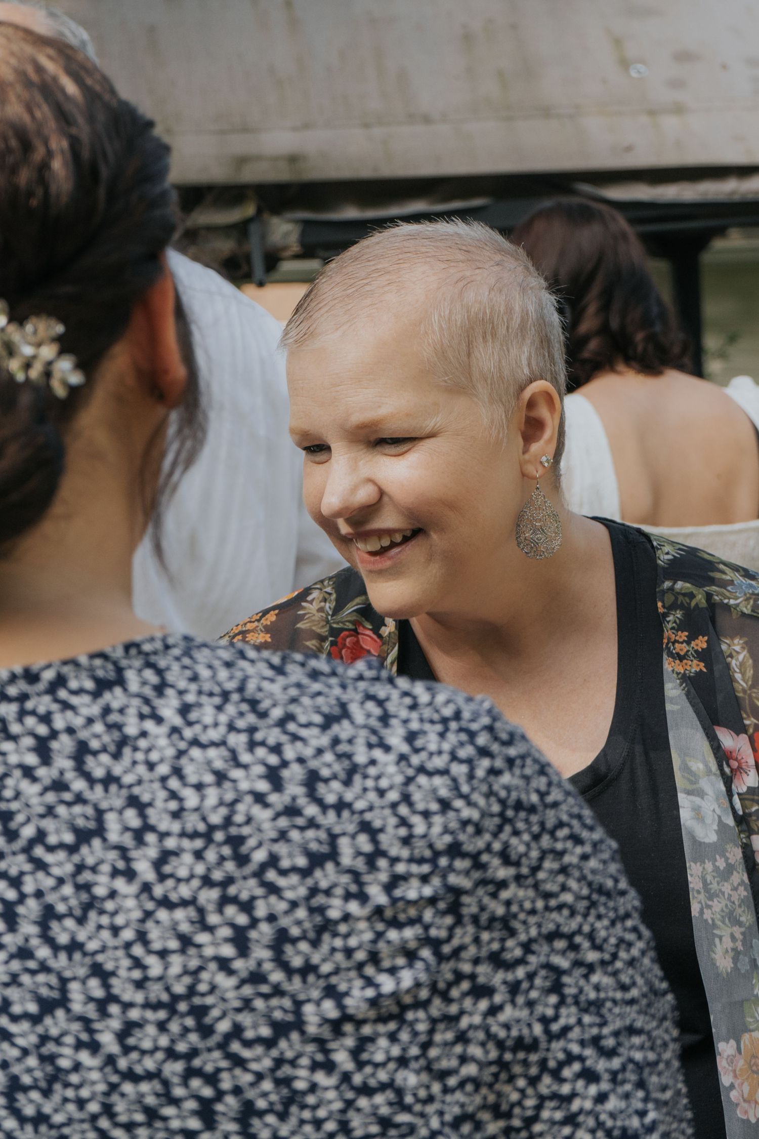 A cancer patient shares a joyful moment during a social gathering, displaying resilience and happiness.