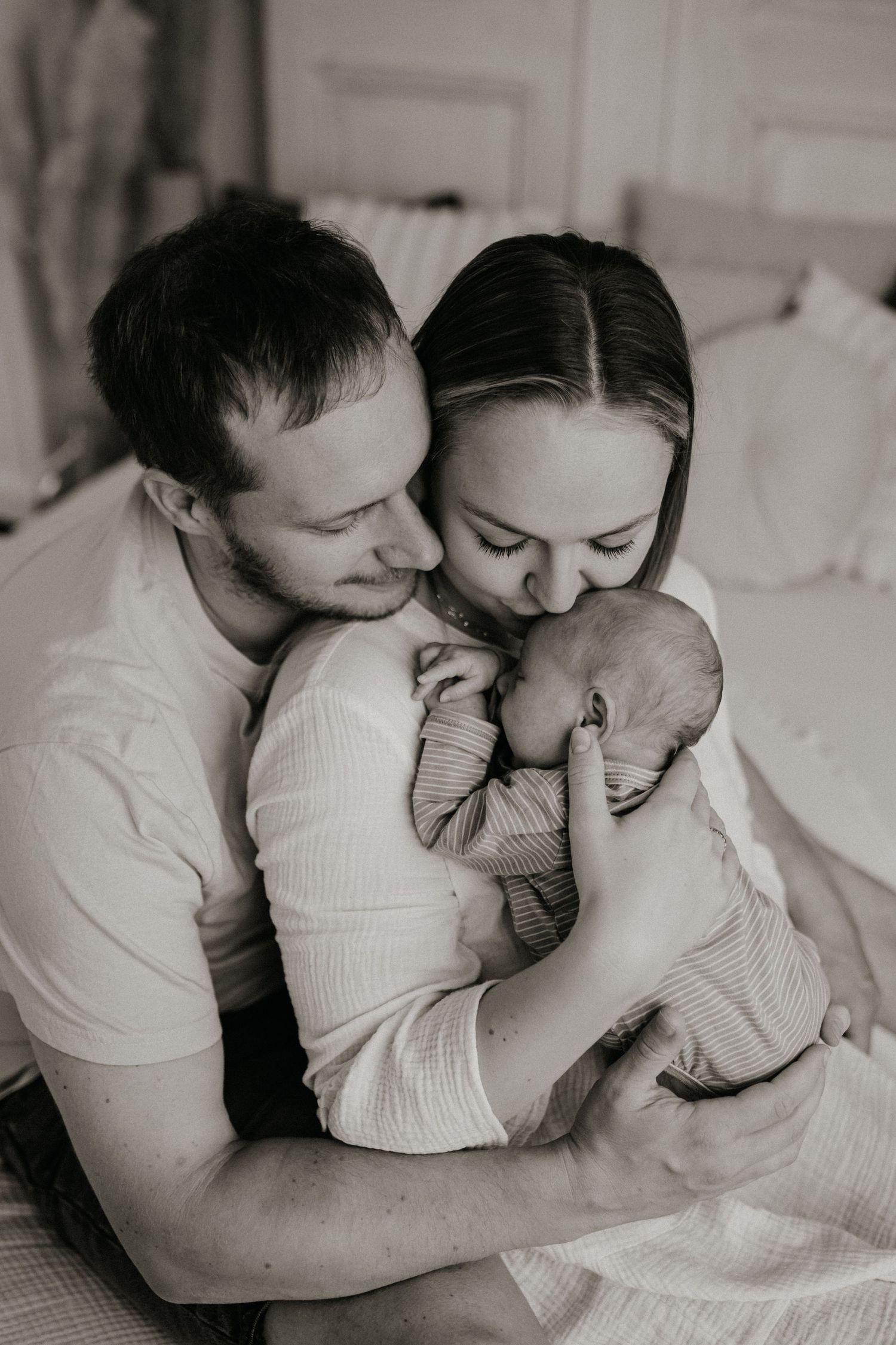 Eltern mit ihrem Baby im modernen, hellen Fotostudio in Coburg – sanftes Tageslicht, neutraler Boho-Stil, authentische Neugeborenenfotografi