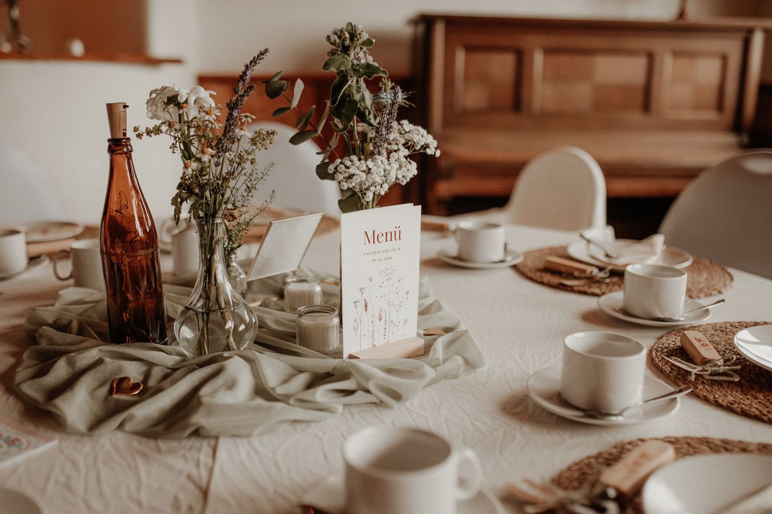 Kerzen, Tische und Blumenarrangements in Sonnefeld – liebevolle Hochzeitsdetails festgehalten in der Reportage.