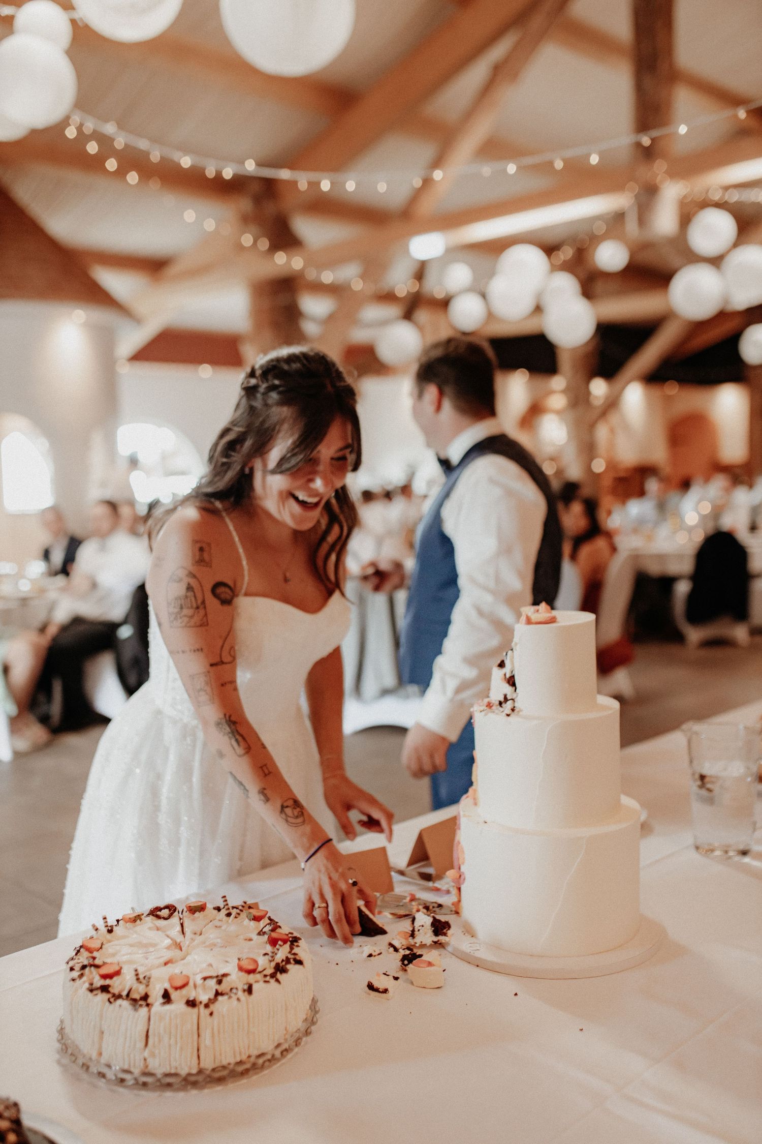 Anschnitt der Hochzeitstorte in Rödental – Hochzeitsreportage fängt fröhliche, ungestellte Momente ein.