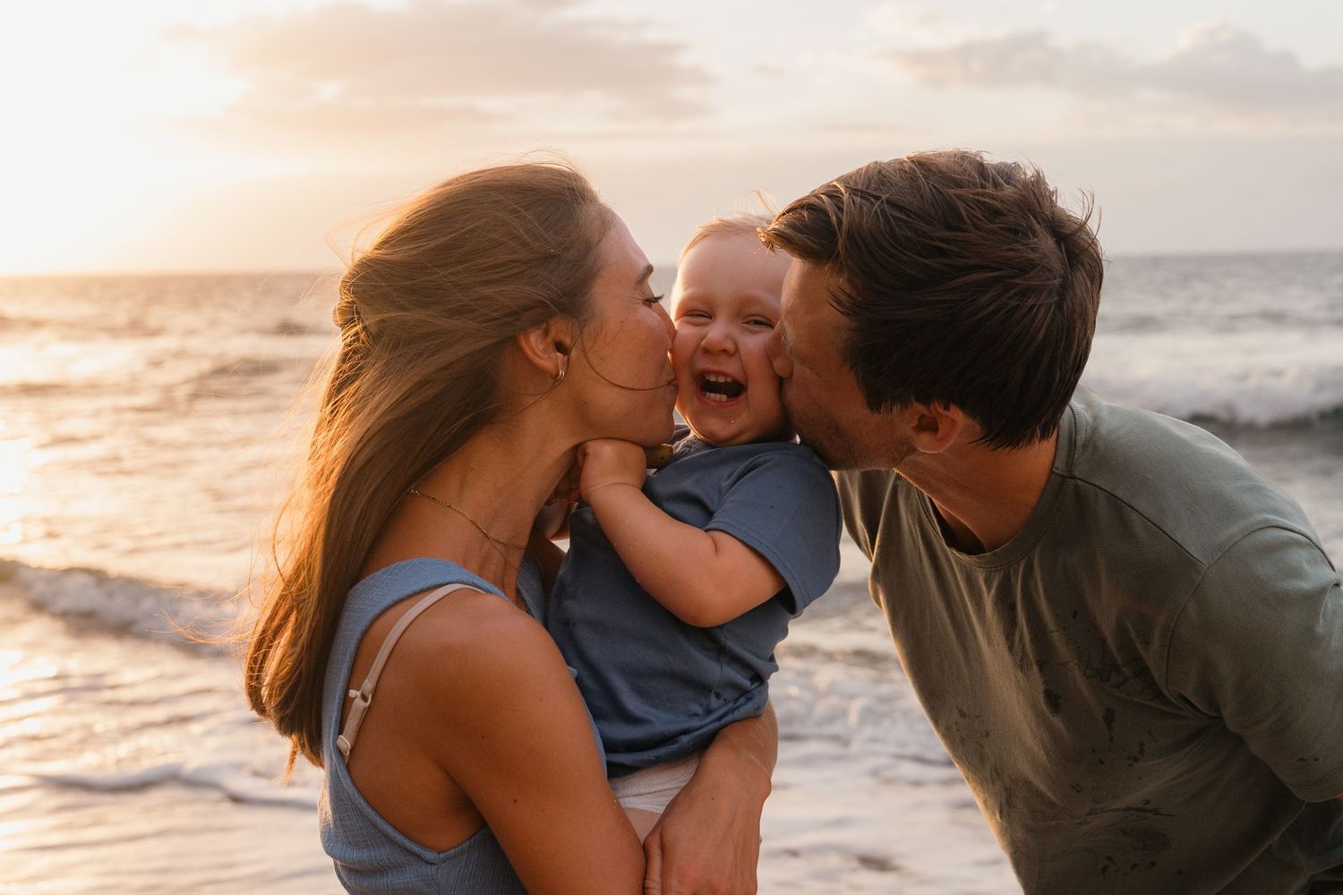 Family sharing a joyful moment together at sunset on the beach.