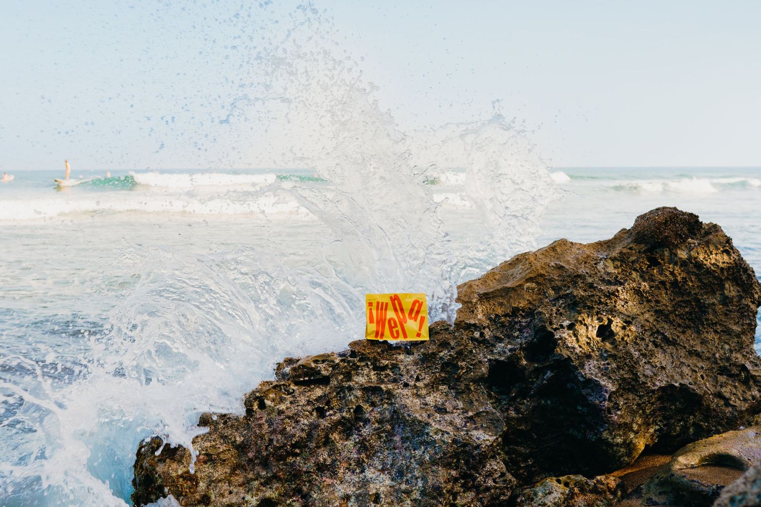 Rocky coastal landscape with crashing waves and ocean spray against dramatic shoreline.