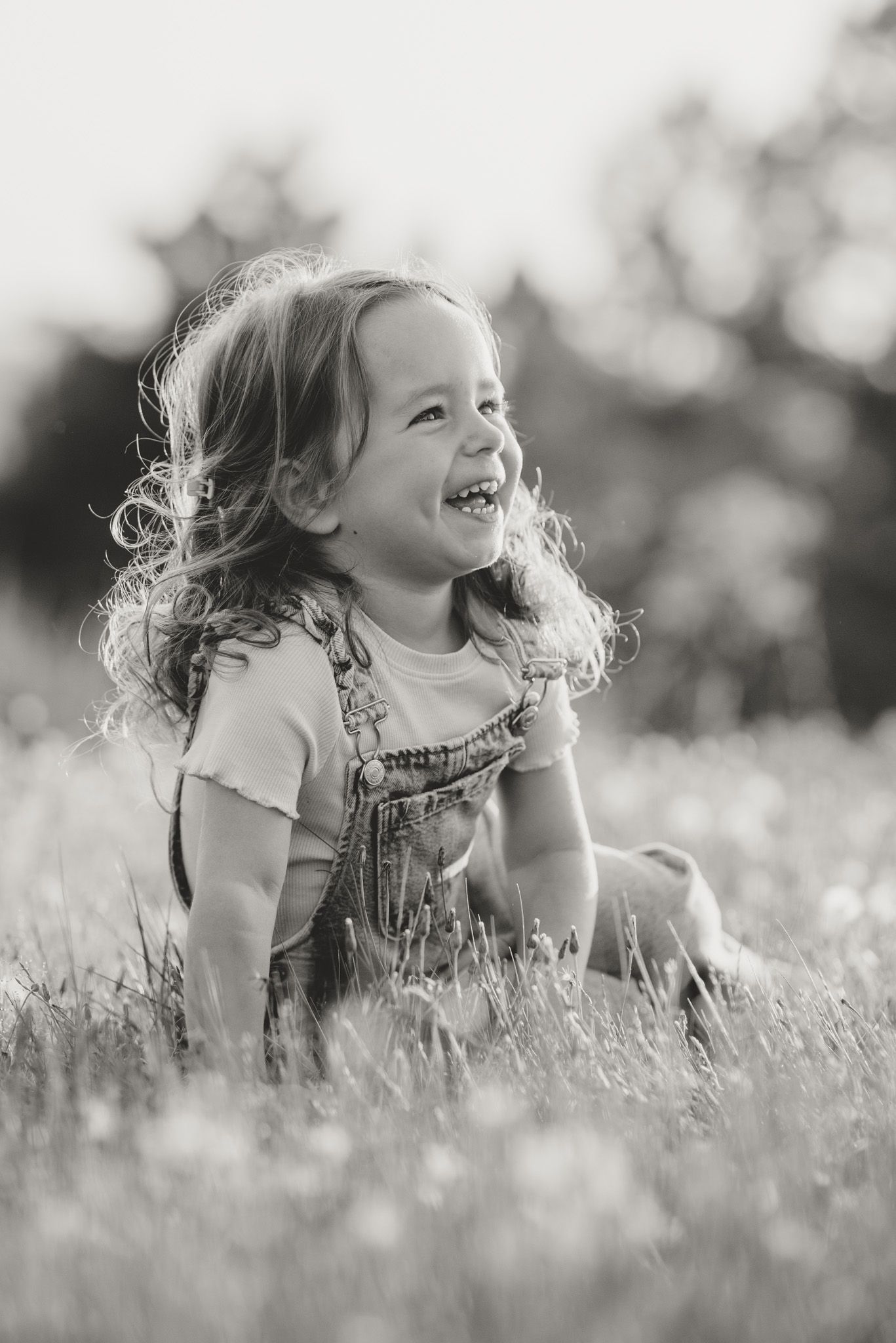 Black and white portrait of a joyful moment in a flower-filled meadow.