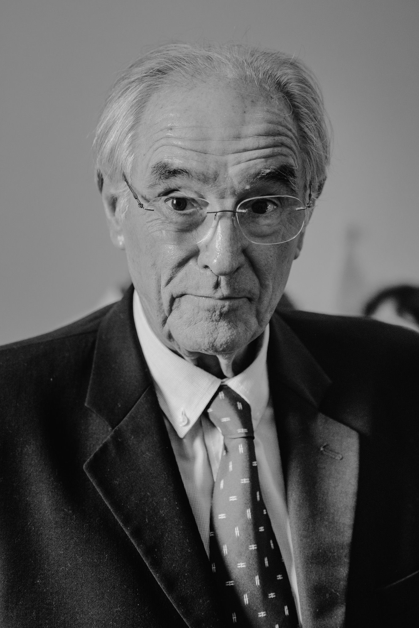 Black and white portrait sequence showing an elderly man in a suit making playful expressions.