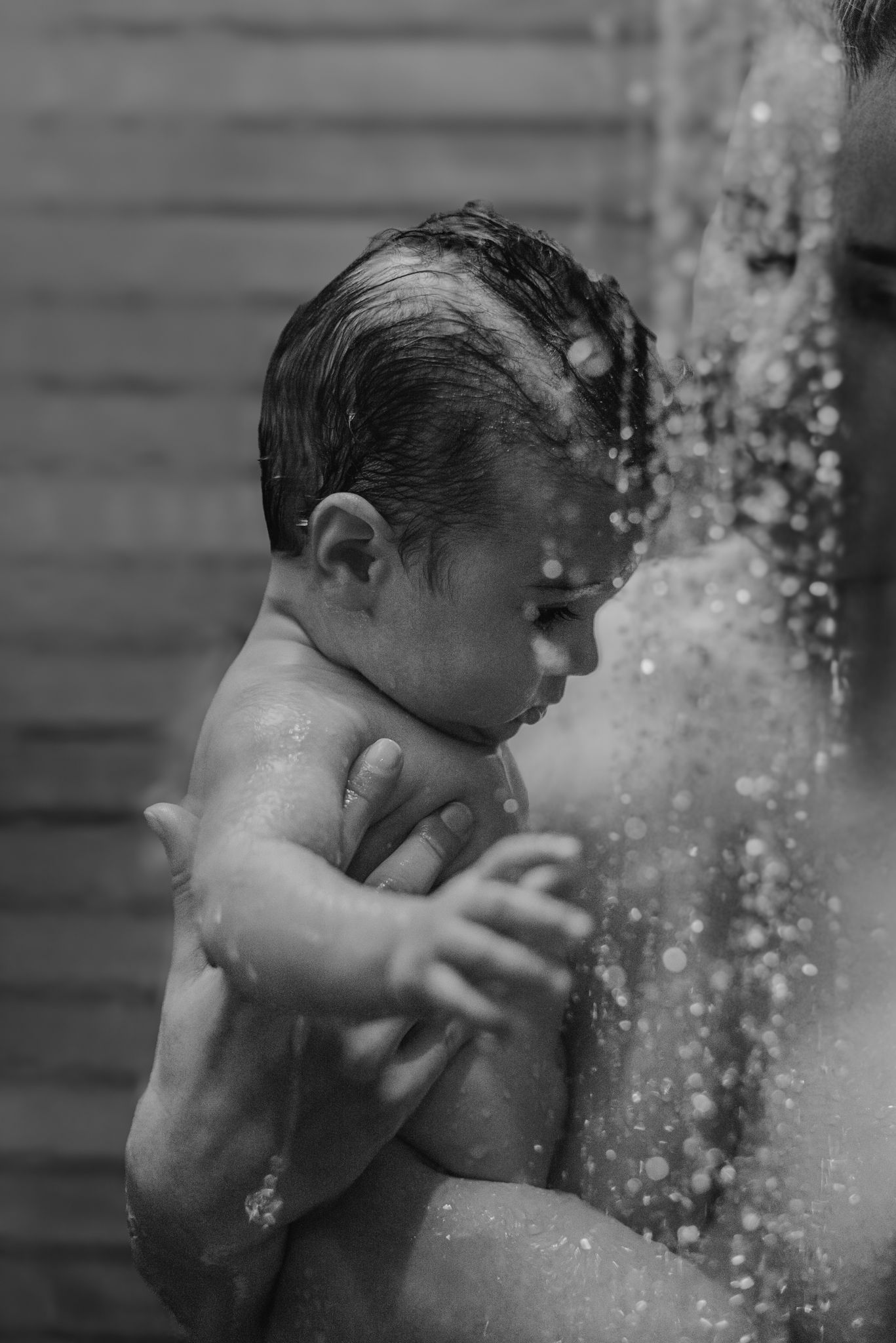 A sequence of black and white photos shows water splashing on someone cooling off on a hot summer day.