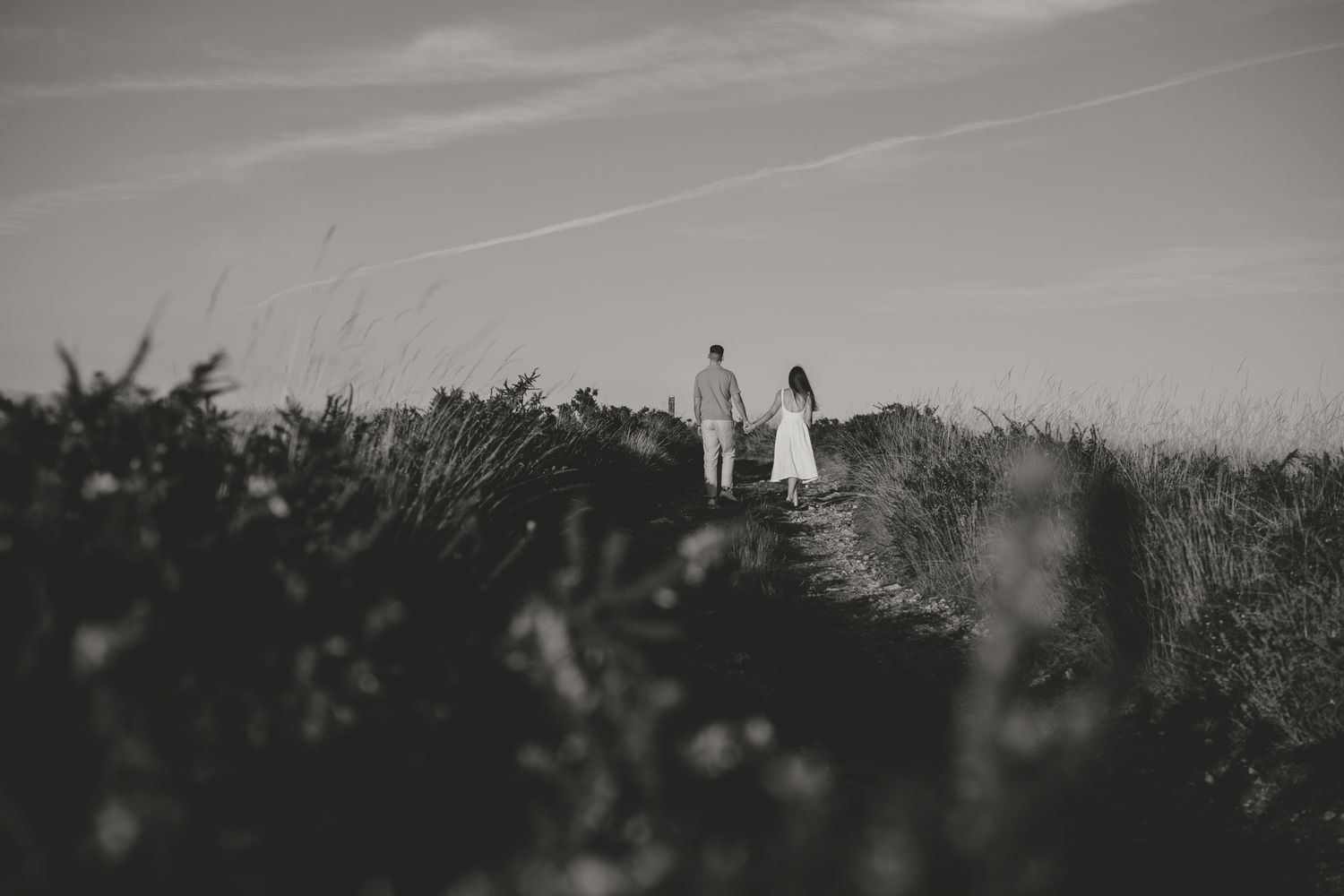 Minimalist black and white landscape photo with distant figures in a field.