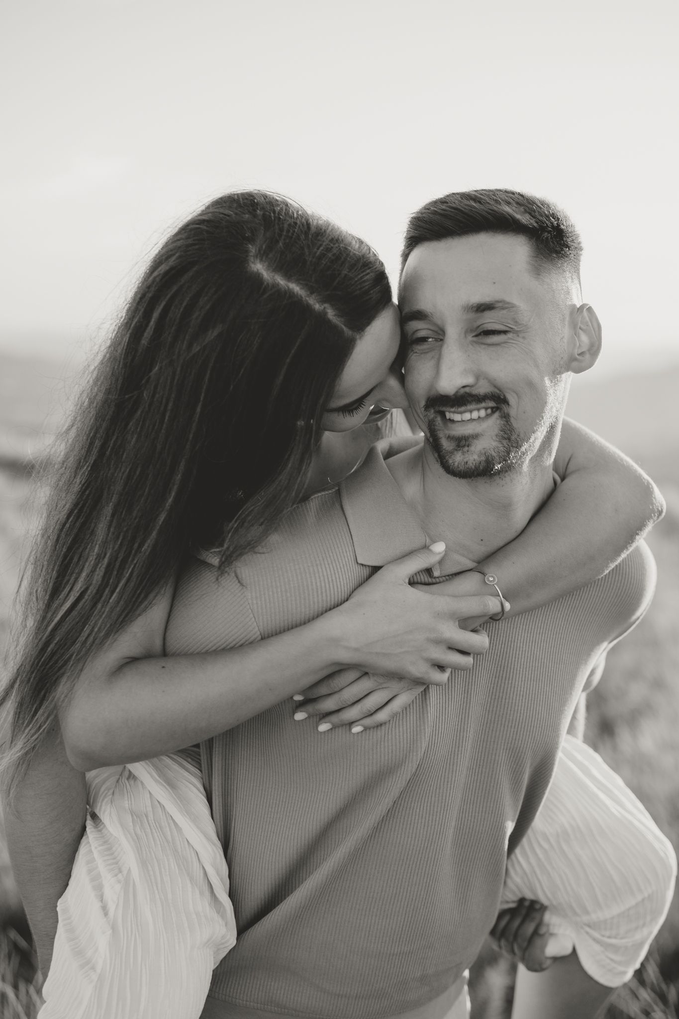 A tender moment captured between two people in close embrace during sunset.
