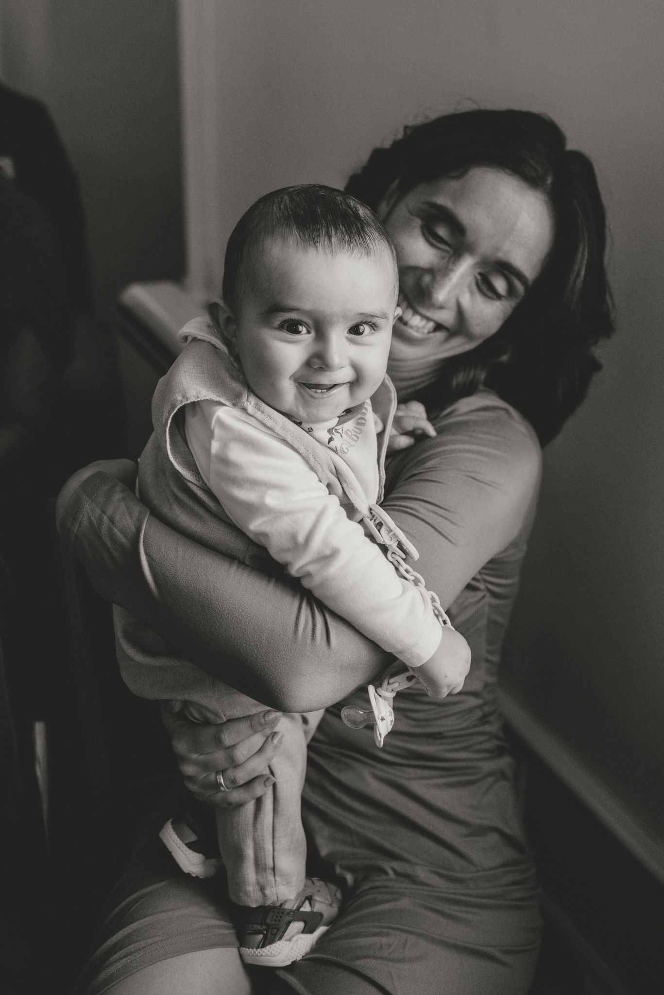 Black and white candid photo of tender moment with small child during celebration.