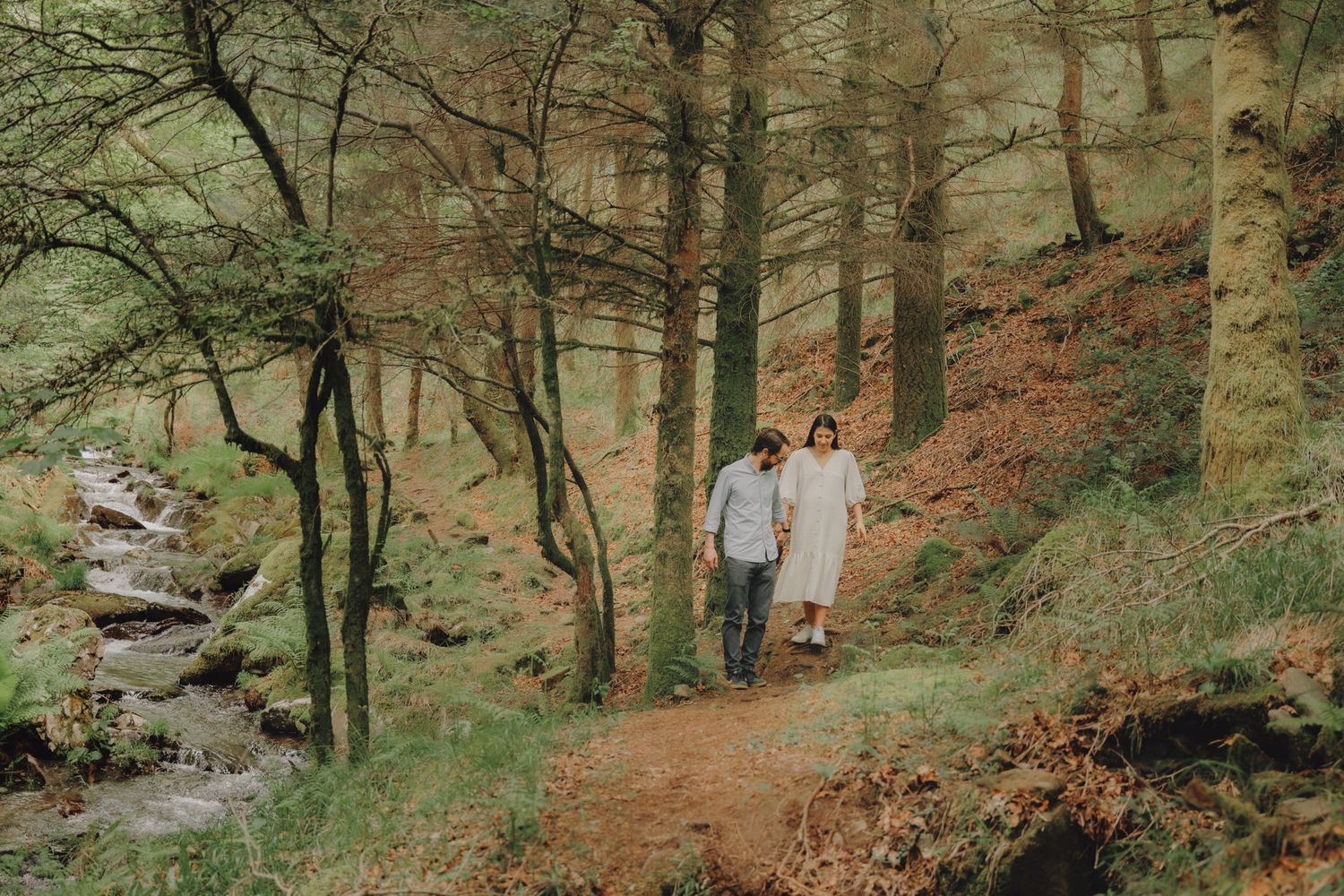 Couple enjoys a peaceful moment together on a wooded hillside trail.