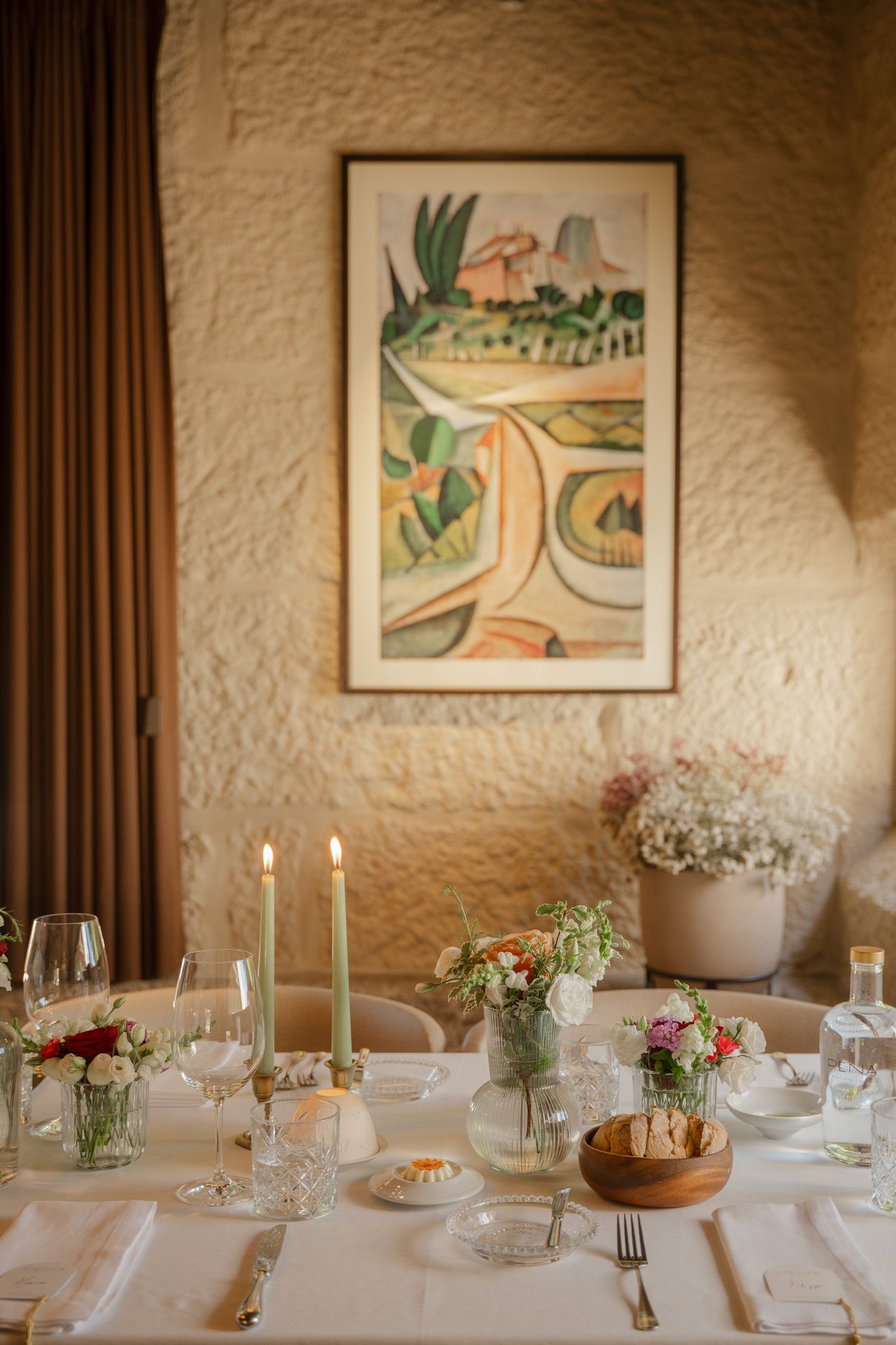 Elegant wedding table setting with white linens and framed artwork.