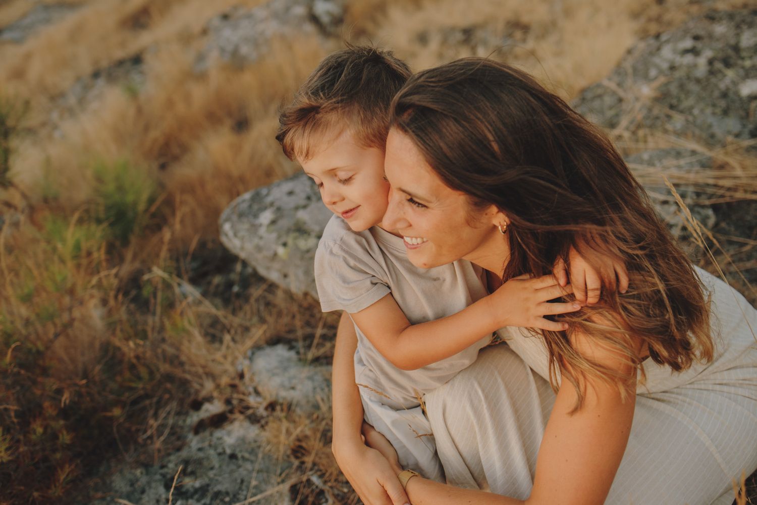 Intimate family portraits in a natural outdoor setting with golden light and mountains.