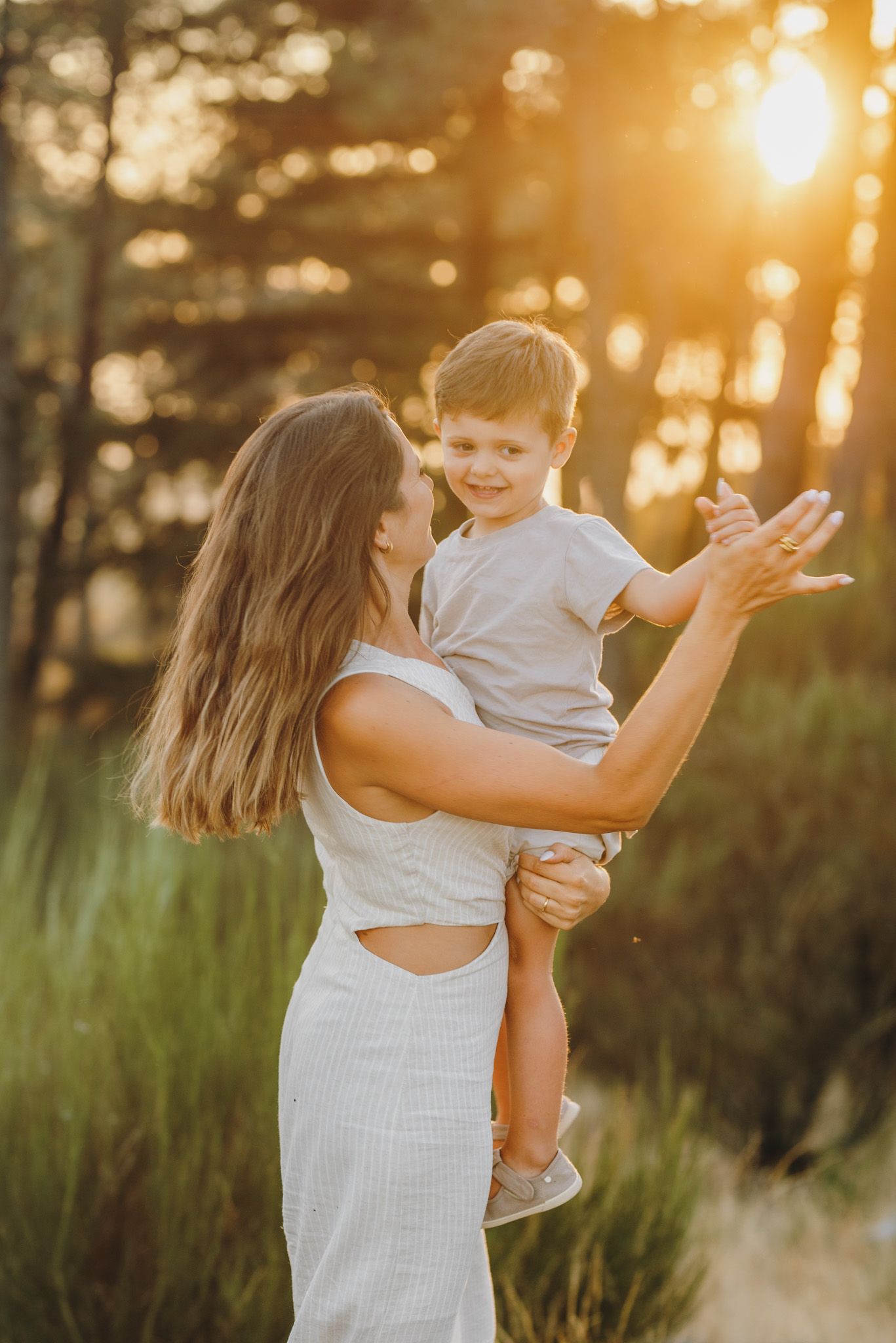 Mother and child sharing joyful interactions during golden hour photoshoot.