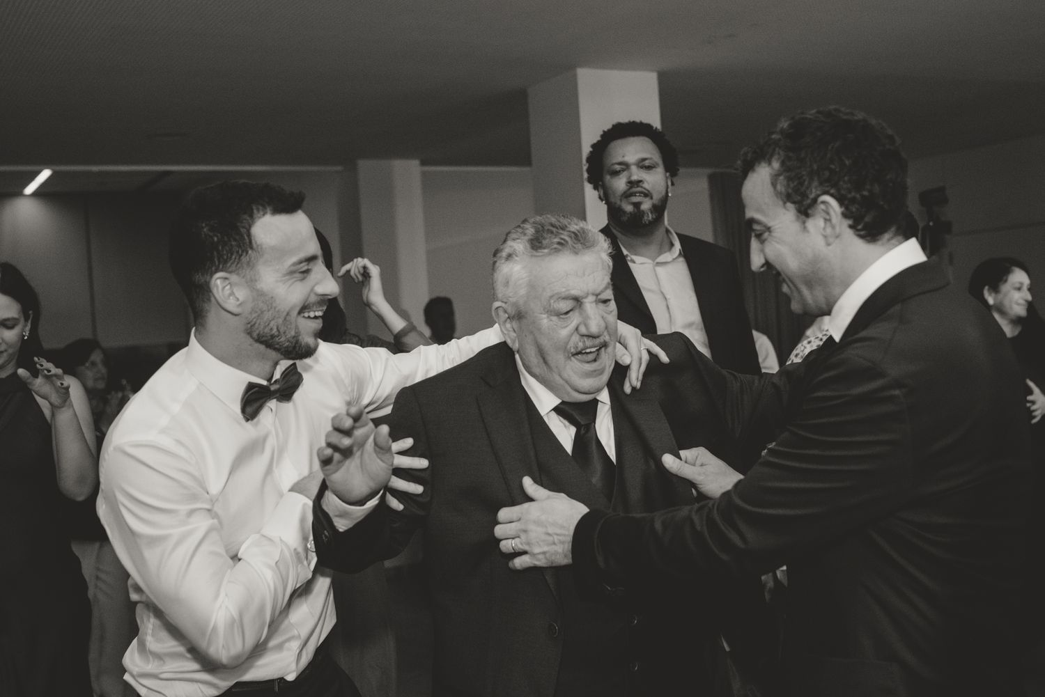 Black and white photo of people dancing and celebrating at a party.