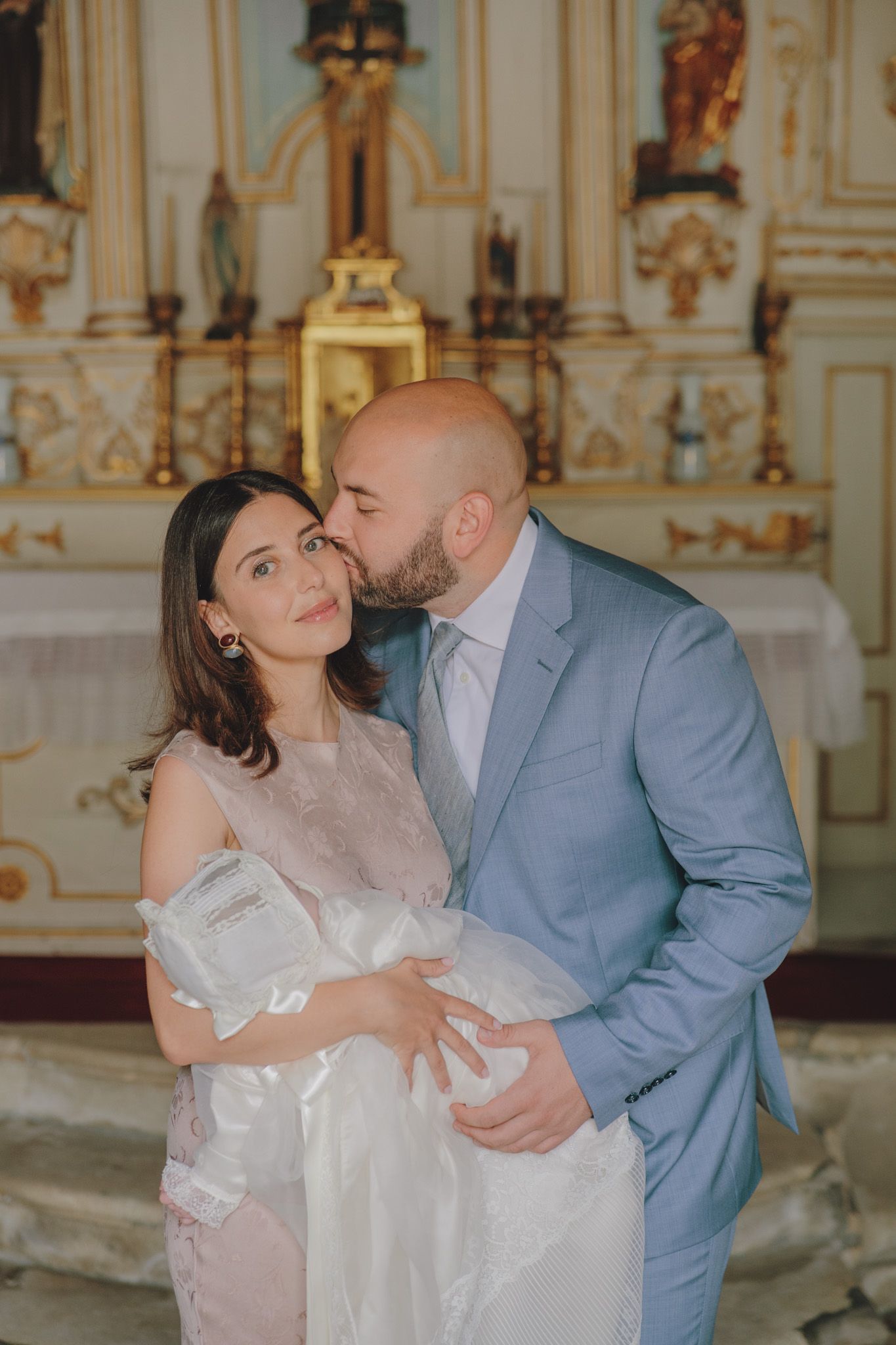 An intimate family moment captured in an ornately decorated church interior.