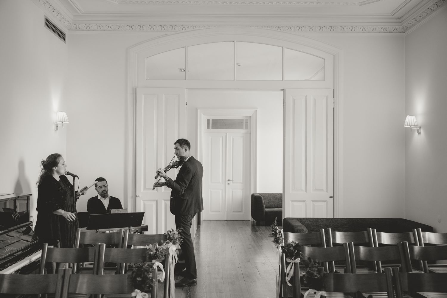 Black and white interior shots of an elegant room being set up for an event.