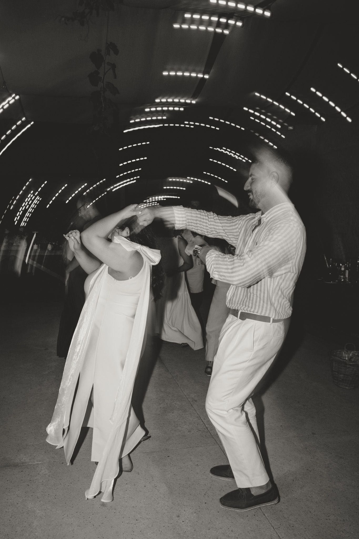 Vintage black and white photo of couples dancing under string lights.