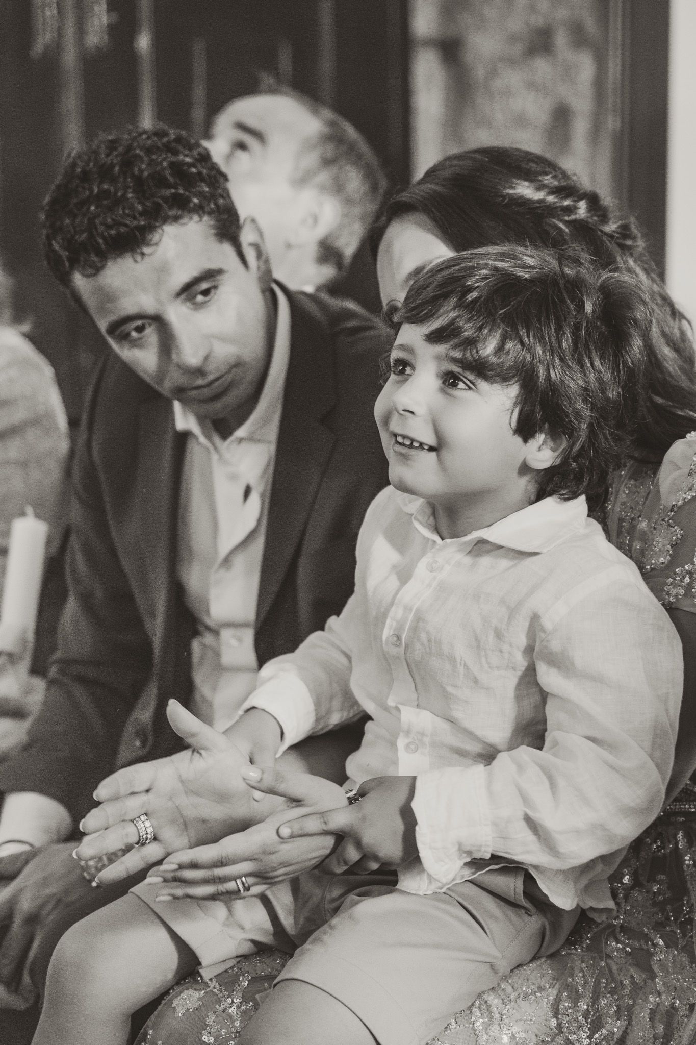 Series of black and white photos capturing intimate family moments during a ceremony.