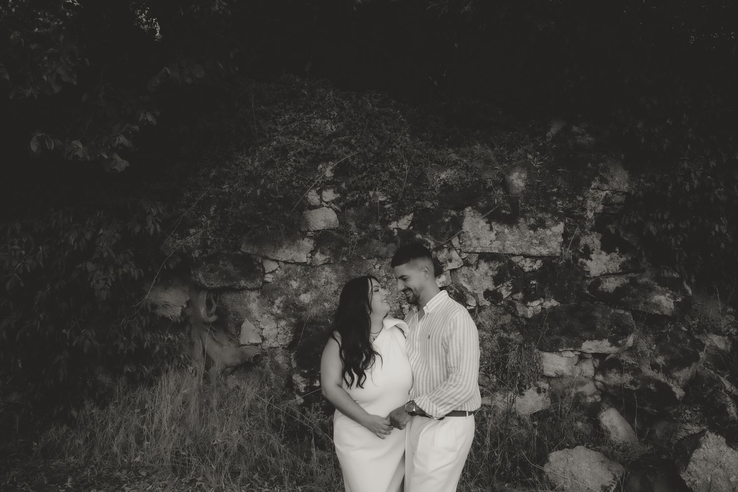 A series of black and white romantic photographs taken in a garden setting at dusk.