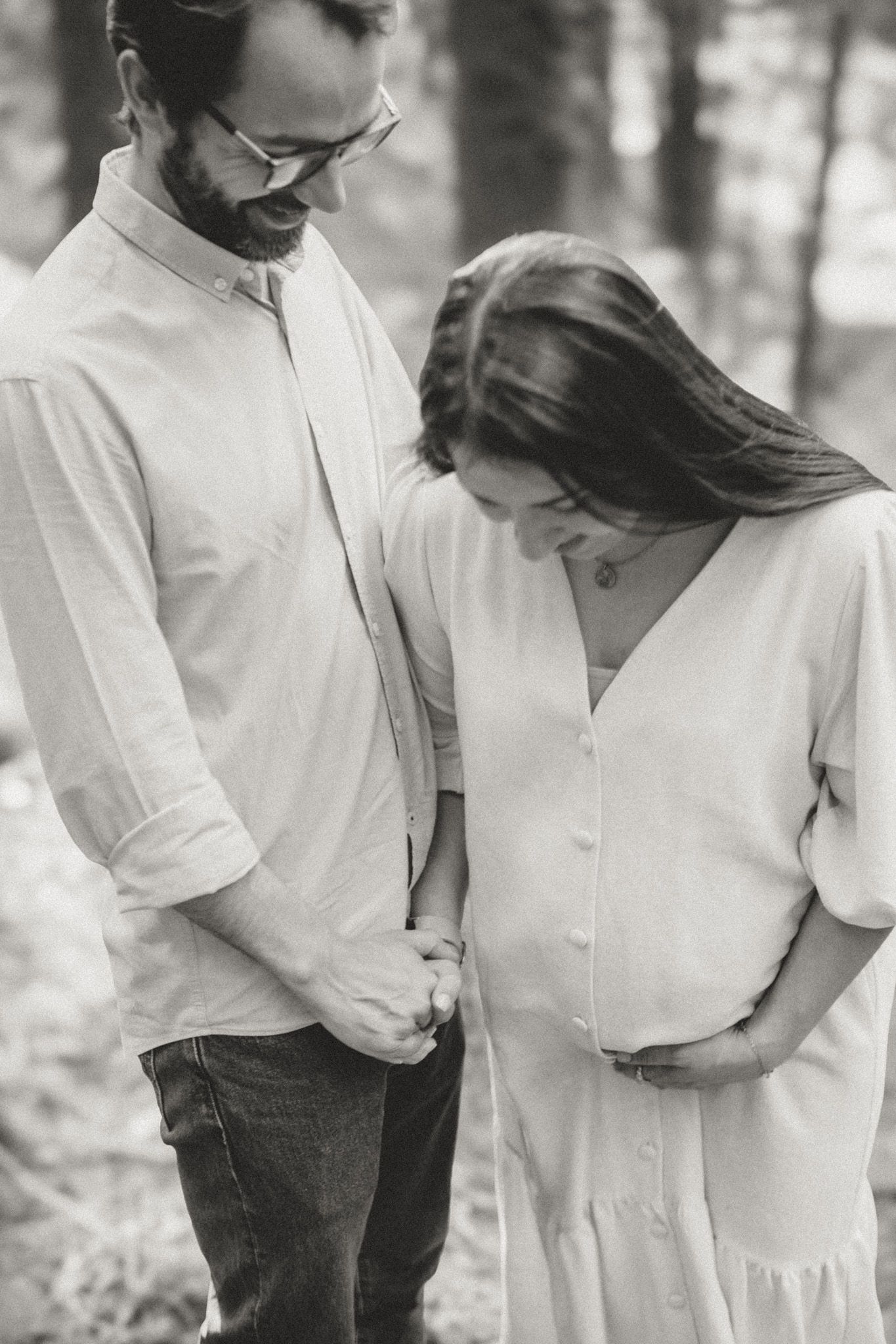A tender black and white moment captured between a couple in matching white outfits.