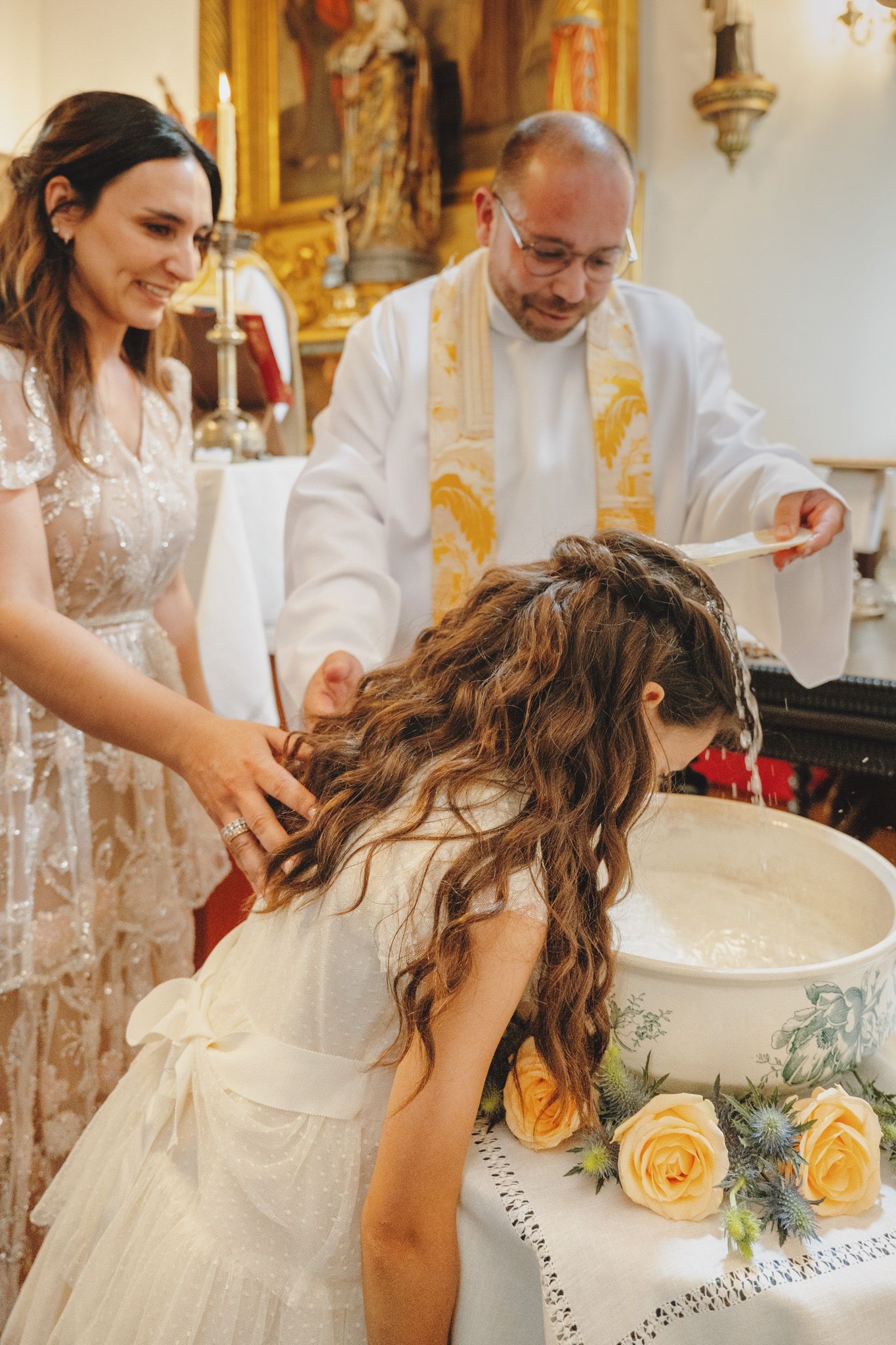 A baptism ceremony taking place in an ornate church with gold details.