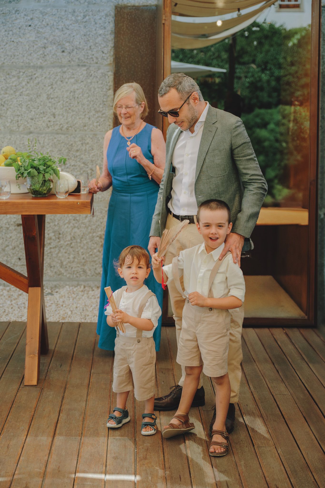 Children in formal attire playing on a wooden deck during a wedding reception.