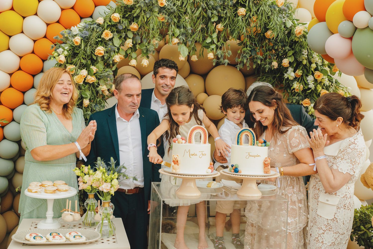 A festive party scene with balloon decorations and guests gathered around tables.