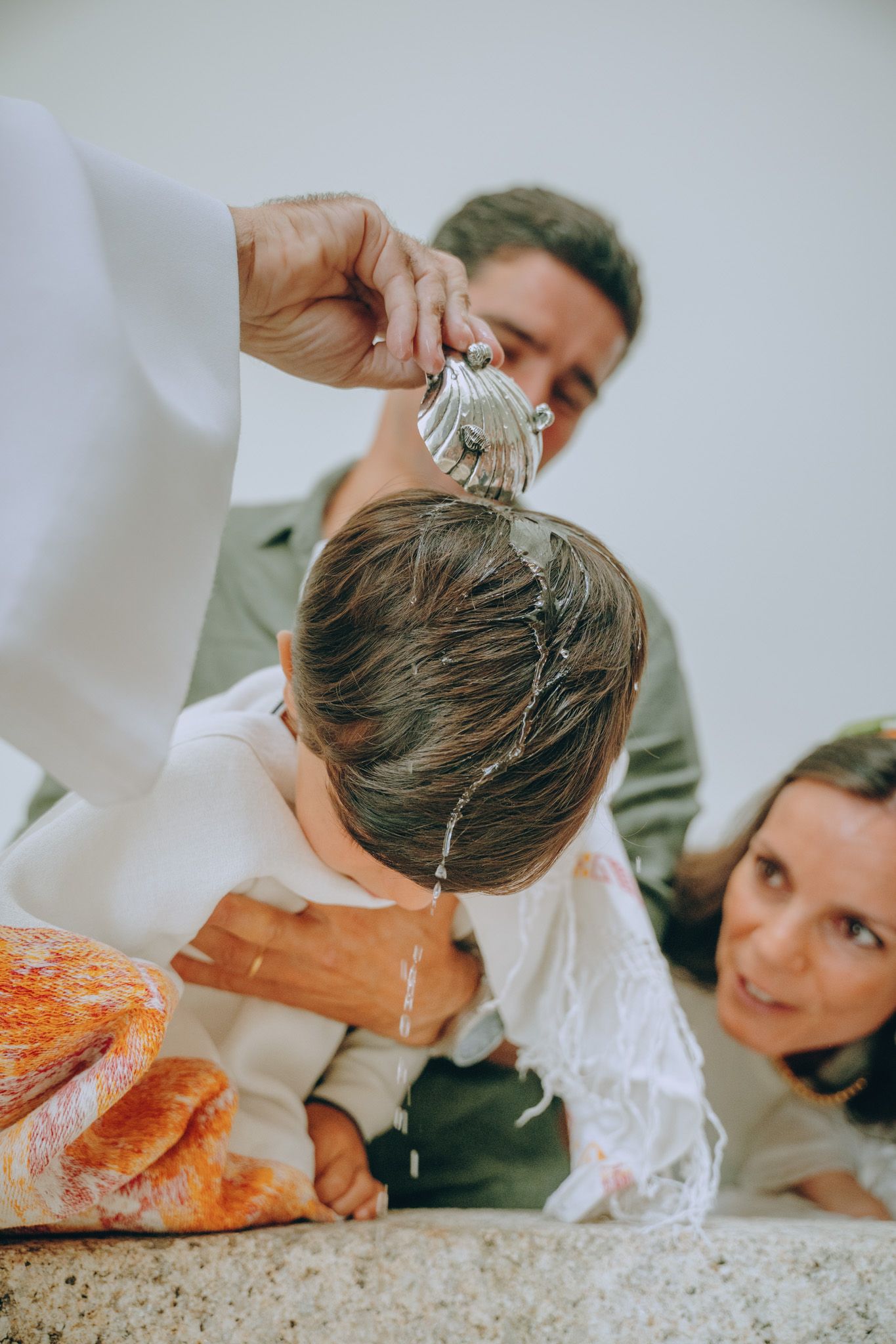 Water being poured over someone's head during a baptism ceremony.