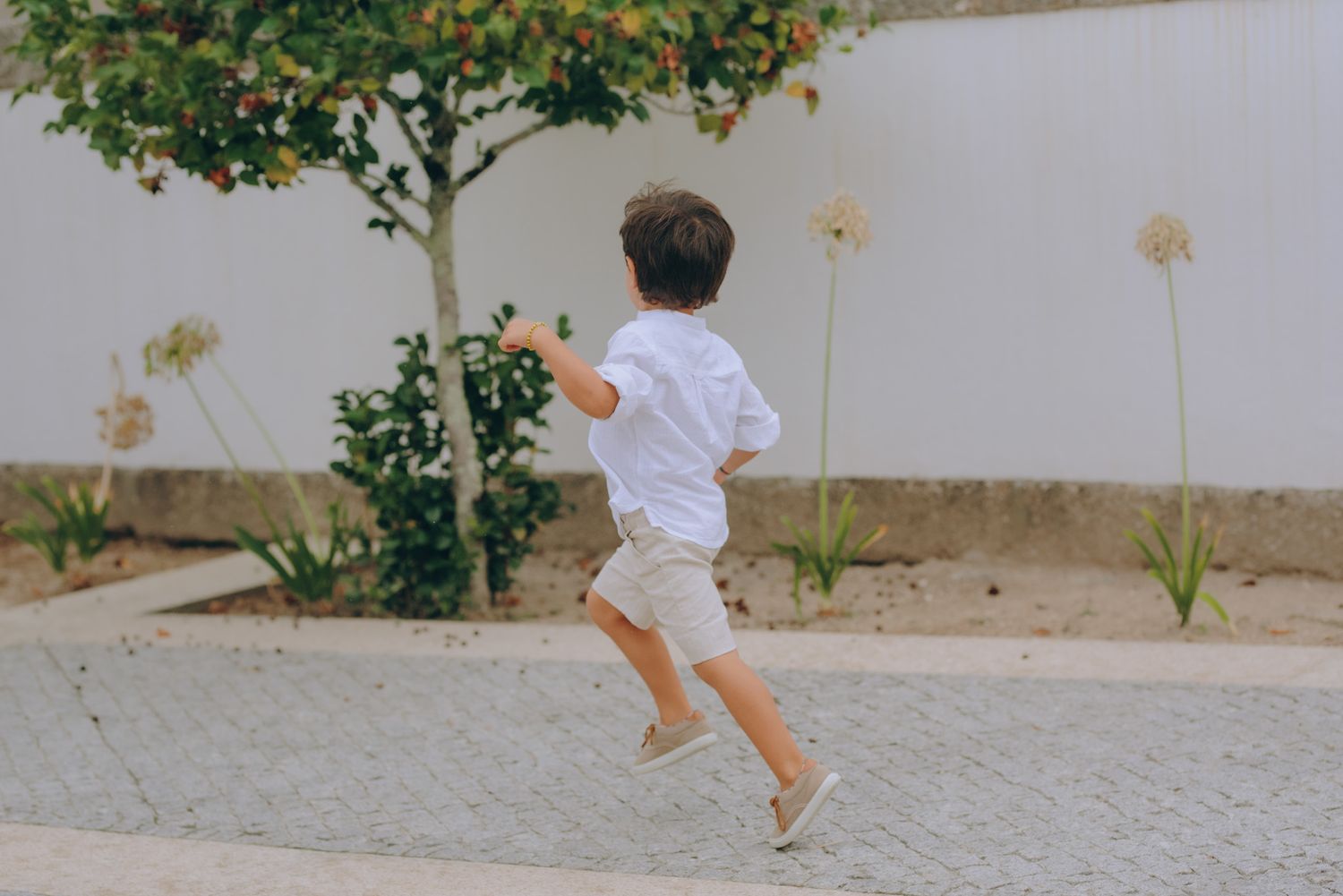 A sequence of photos showing someone running and jumping on a paved pathway near greenery.
