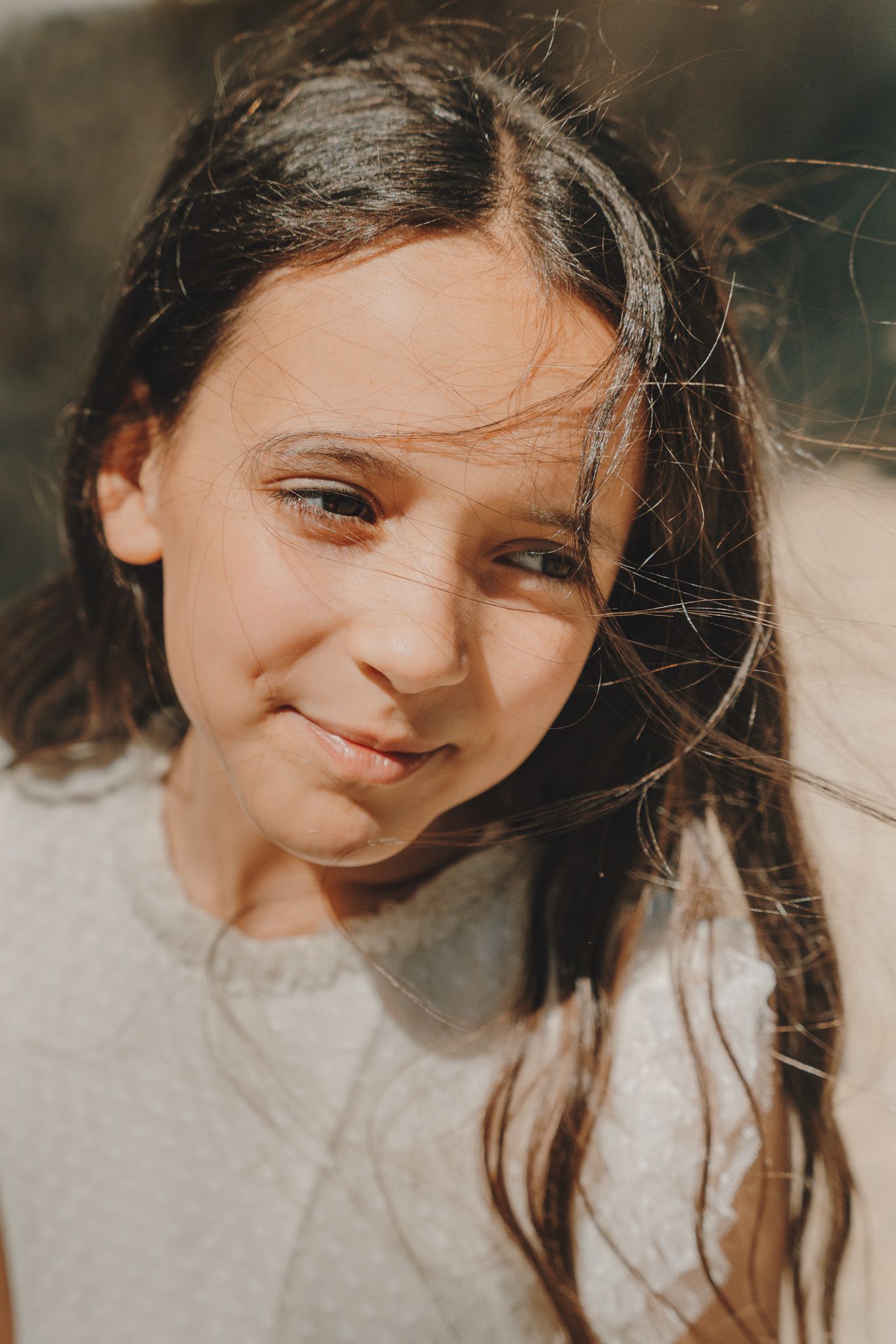 A series of close-up portraits showing joyful expressions and windswept hair against a light background.