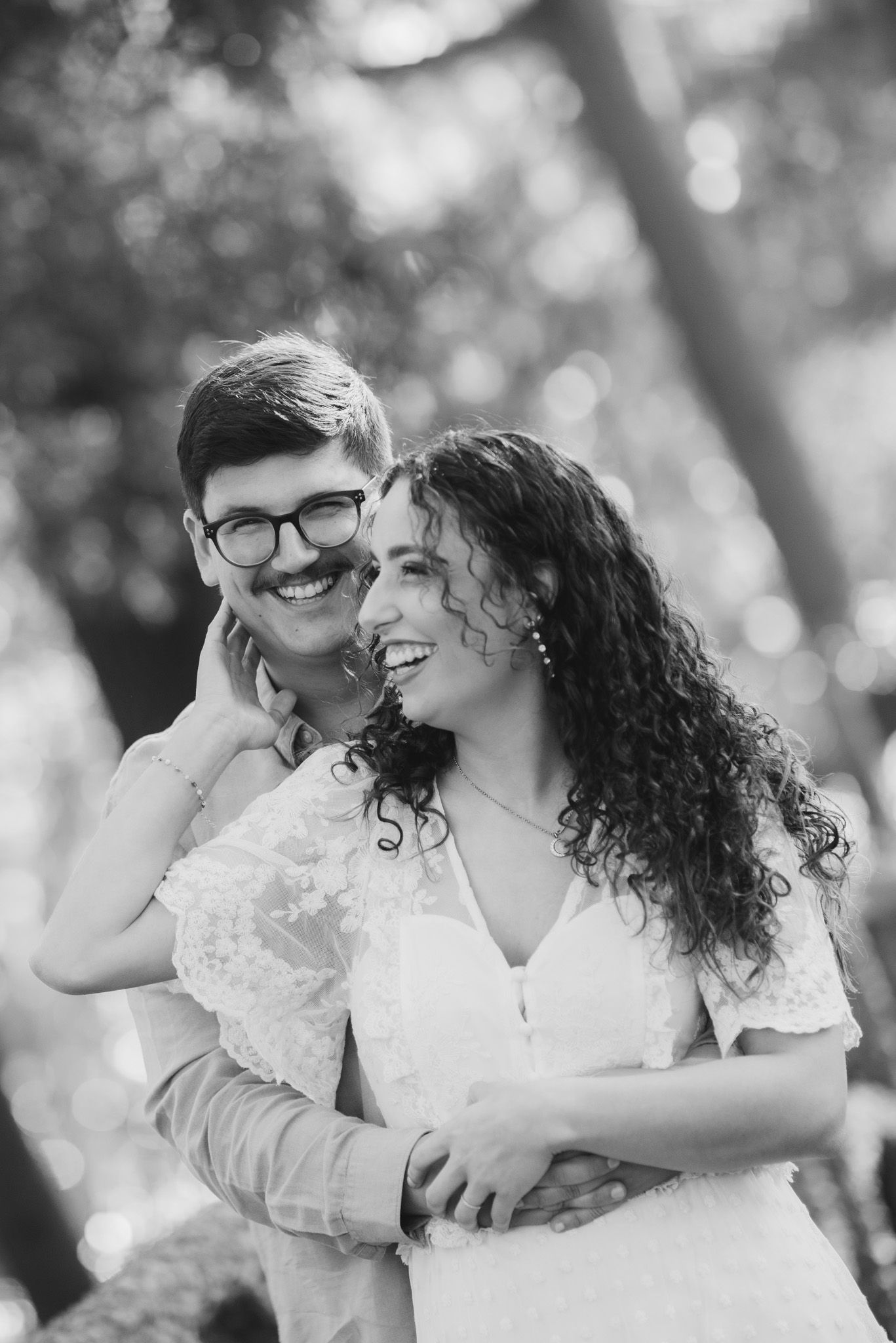 Intimate black and white portrait of a couple embracing outdoors.