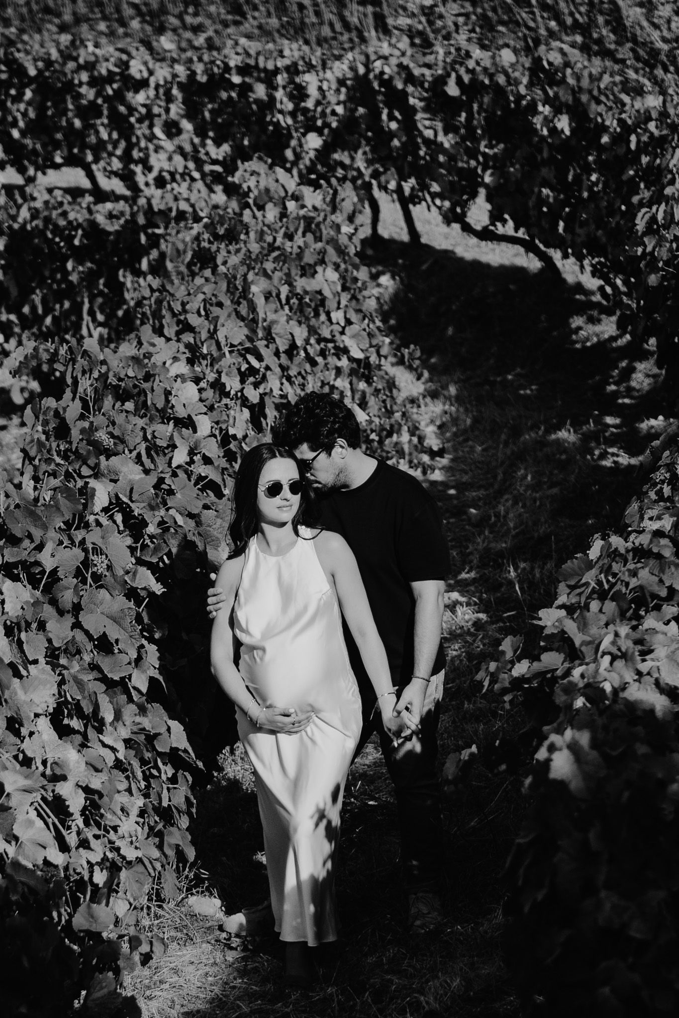 Black and white portrait session among grapevines with natural shadows and light.